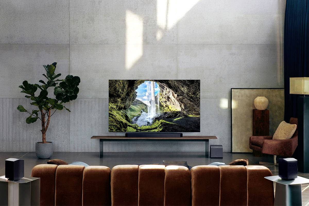 Ein modernes Wohnzimmer mit einem großen Fernseher auf einem niedrigen Tisch. Der Bildschirm zeigt eine Höhle mit einem Wasserfall.