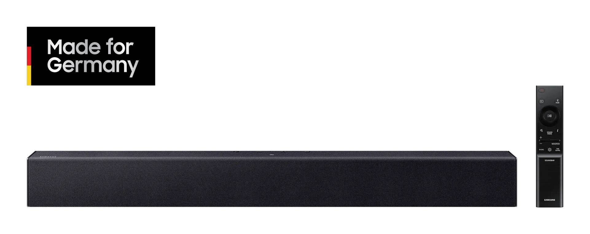Schwarze Soundbar mit Fernbedienung daneben; 'Made for Germany' Logo oben links. Audio-Produkt präsentiert für den deutschen Markt.