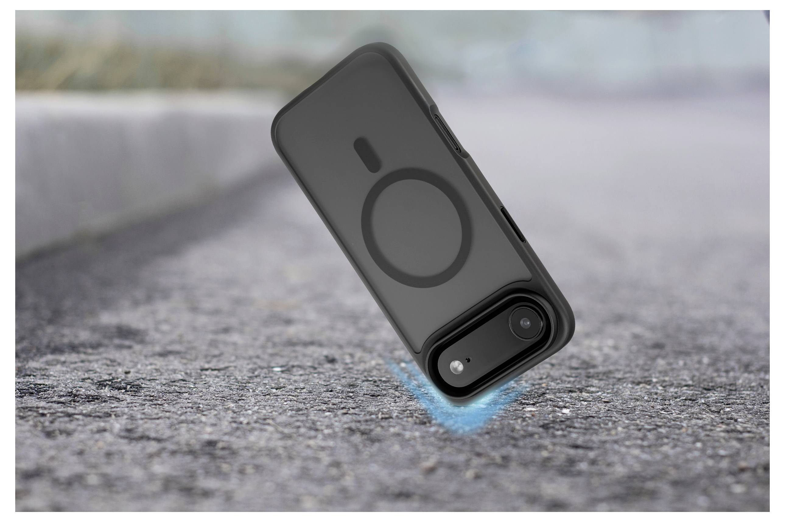 Ein Smartphone in einem Schutzgehäuse wird gezeigt, wie es auf eine raue Betonoberfläche fällt und dabei die Robustheit und Stoßfestigkeit des Gehäuses hervorhebt.