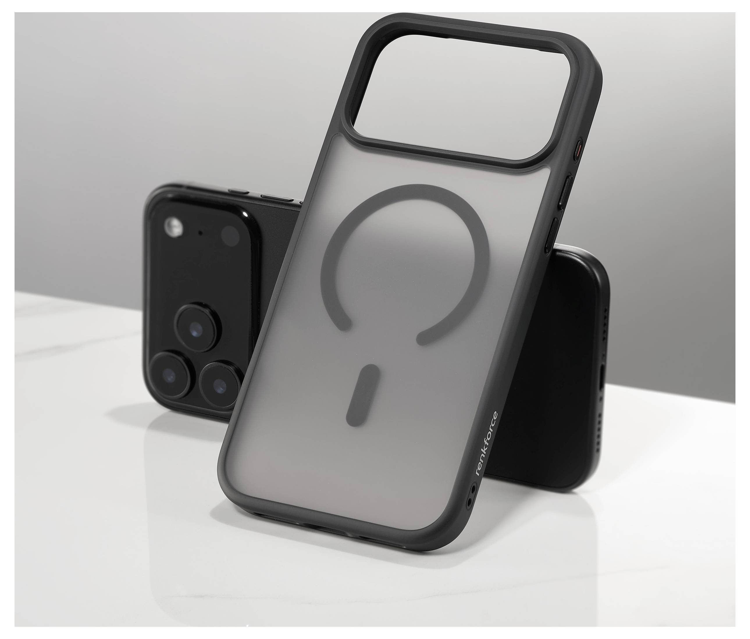 Ein schwarzes Smartphone liegt auf einem Tisch neben einer durchsichtigen Handyhülle, die auf ihrer Rückseite ein Fragezeichen-Design aufweist.