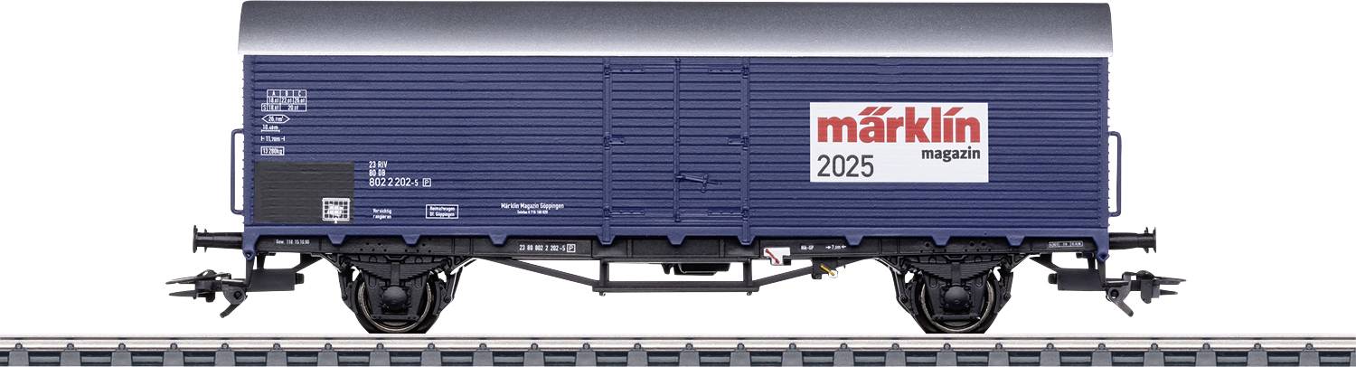 Blauer Modell-Güterwaggon auf Gleisen mit 'märklin magazin 2025' Aufschrift, detaillierte Beschriftungen und Räder sind sichtbar.