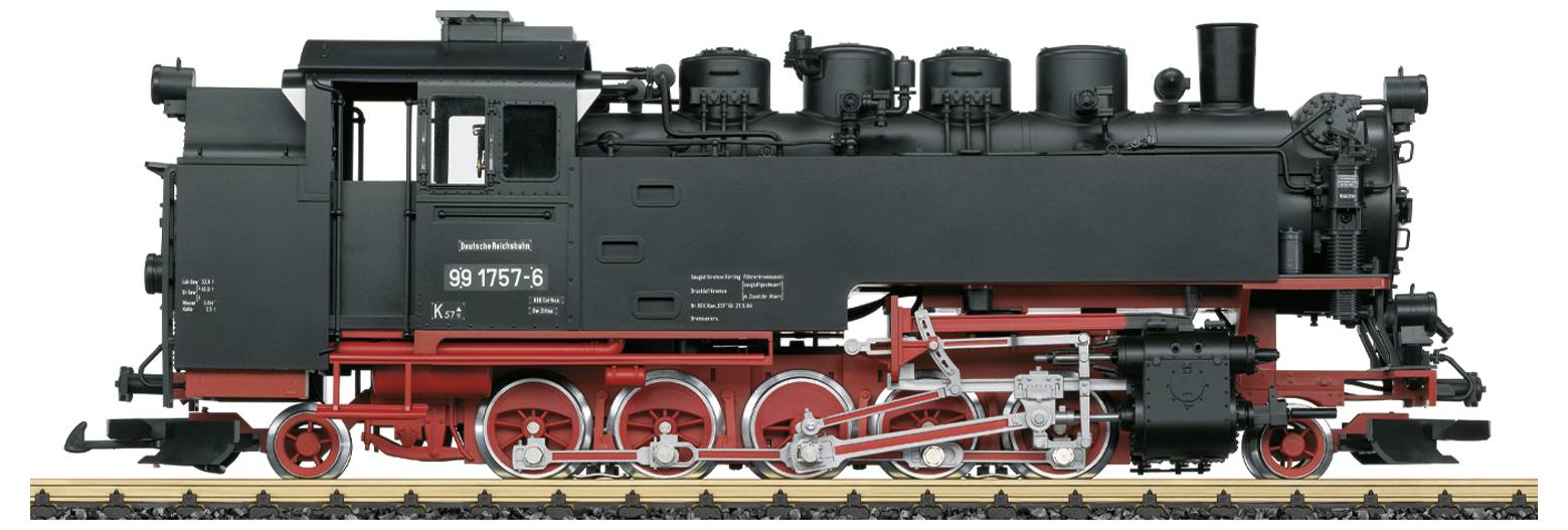 Eine historische Dampflokomotive auf einem Gleis mit schwarzer Lackierung und roten Details. Zahlreiche Rohre und Mechanismen sind sichtbar.