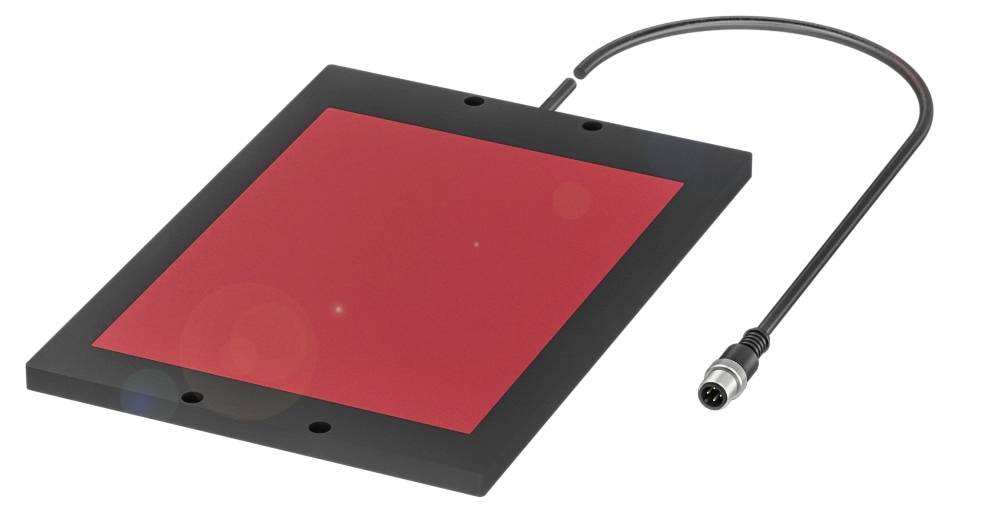 Flache, rechteckige elektronische Platte mit schwarzem Rand und roter Oberfläche. Ein Kabel mit Stecker ist an der Platte befestigt.