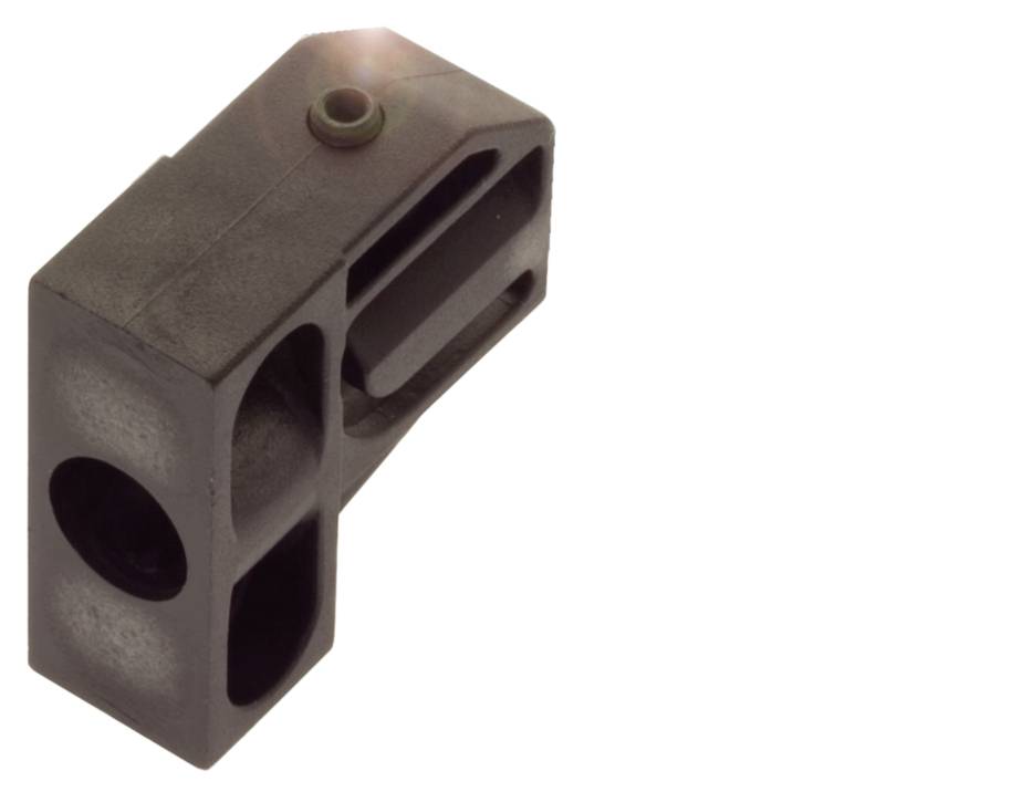 Ein rechteckiges, dunkles Metallteil mit zwei runden Öffnungen und einem erhabenen runden Punkt auf der Oberfläche.