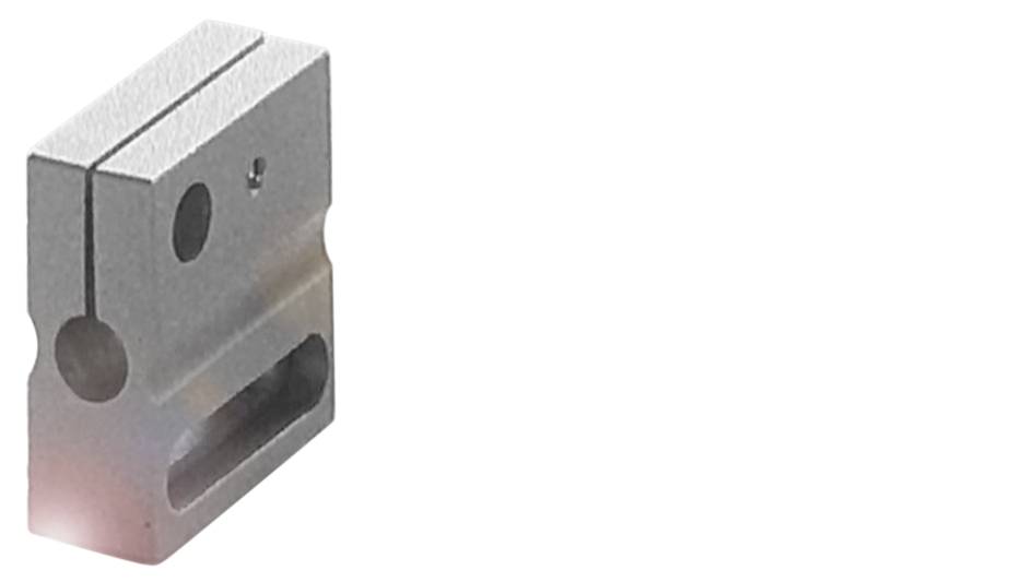 Metallblock mit verschiedenen Bohrungen auf weißem Hintergrund.