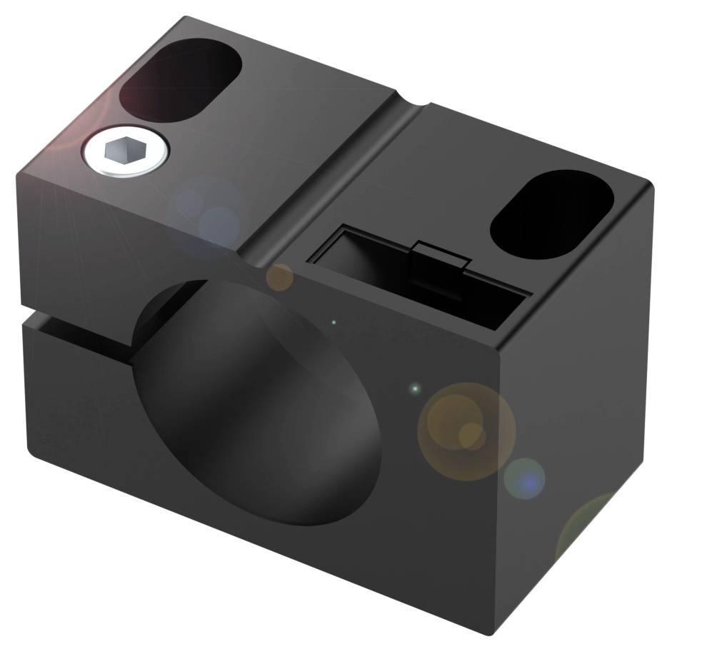 Schwarzes, rechteckiges Maschinenteil mit einer runden Öffnung in der Mitte, enthält eine Schraube links oben.