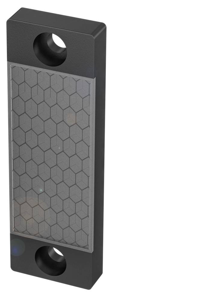 Ein rechteckiges, schwarzes Gerät mit zwei runden Löchern und einer Wabenstruktur auf der Oberfläche.