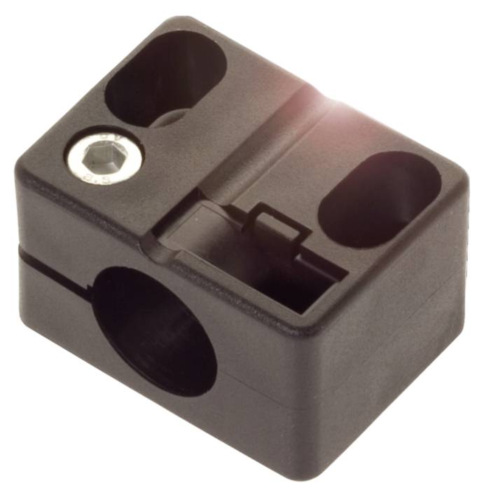 Ein schwarzer Kunststoffblock mit mehreren Aussparungen und einer Metallschraube oben links.