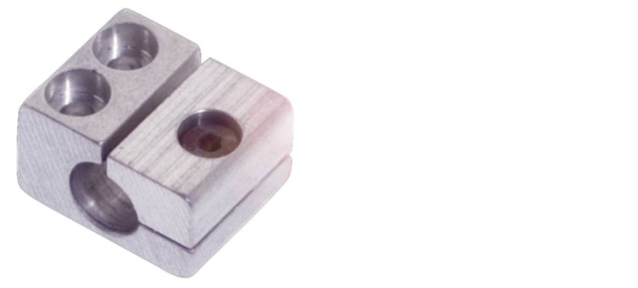 Ein Metallwürfel mit drei runden Löchern und einem runden Einlass an der Seite.