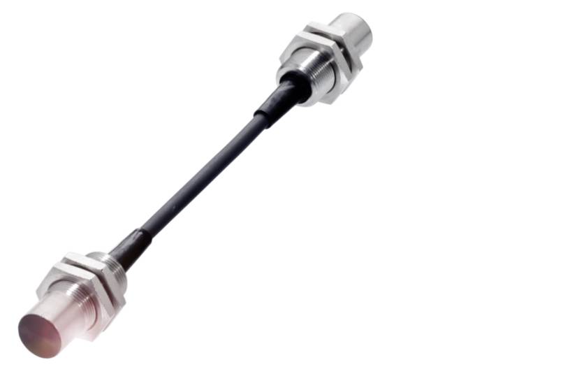 Metallischer Sensor mit Kabelverbindung zwischen zwei Enden, vermutlich Teil eines Maschinenbauteils oder einer technischen Installation.