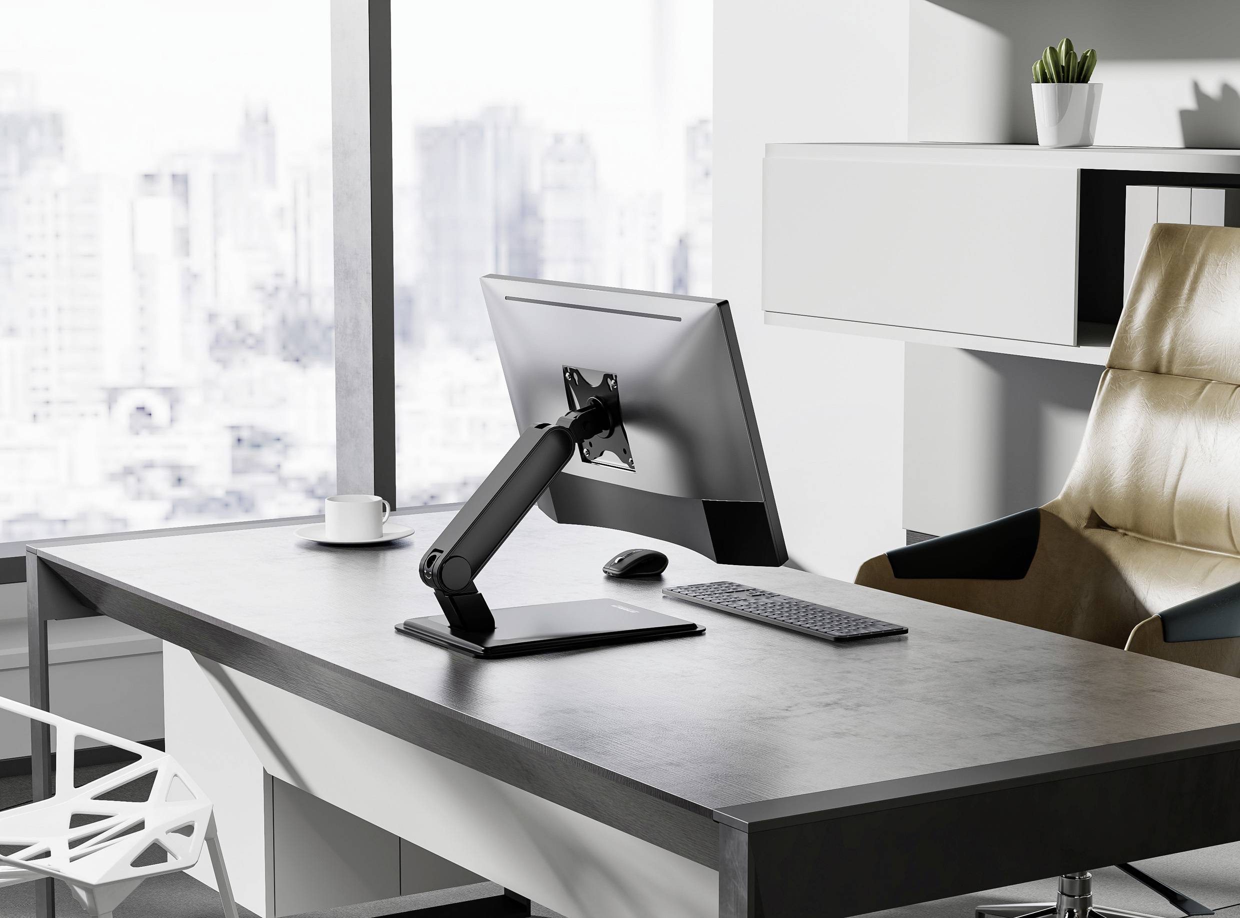 Ein modernes Büroambiente mit einem Computermonitor auf einem verstellbaren Ständer, Tastatur und Maus auf einem aufgeräumten Schreibtisch mit Blick auf eine Stadtlandschaft.