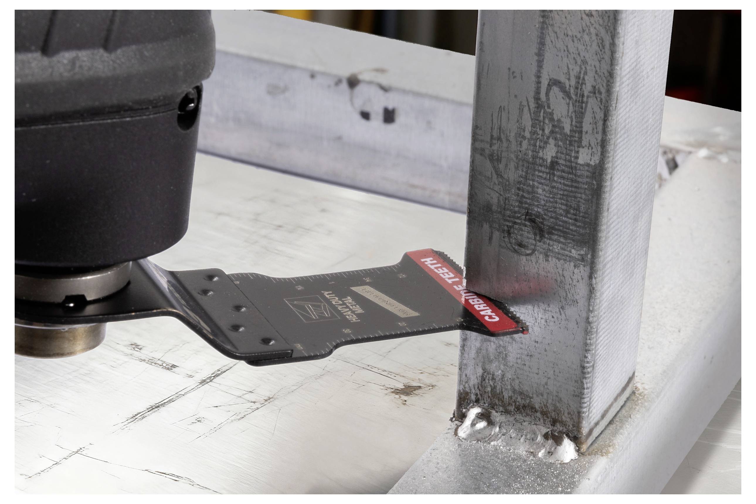 Eine Nahaufnahme eines Metallschneidewerkzeugs, das präzise eine Ecke eines Stahlträgers durchschneidet. Das Werkzeug ist in einem dunklen Griff gehalten, was Präzision und Details zeigt.