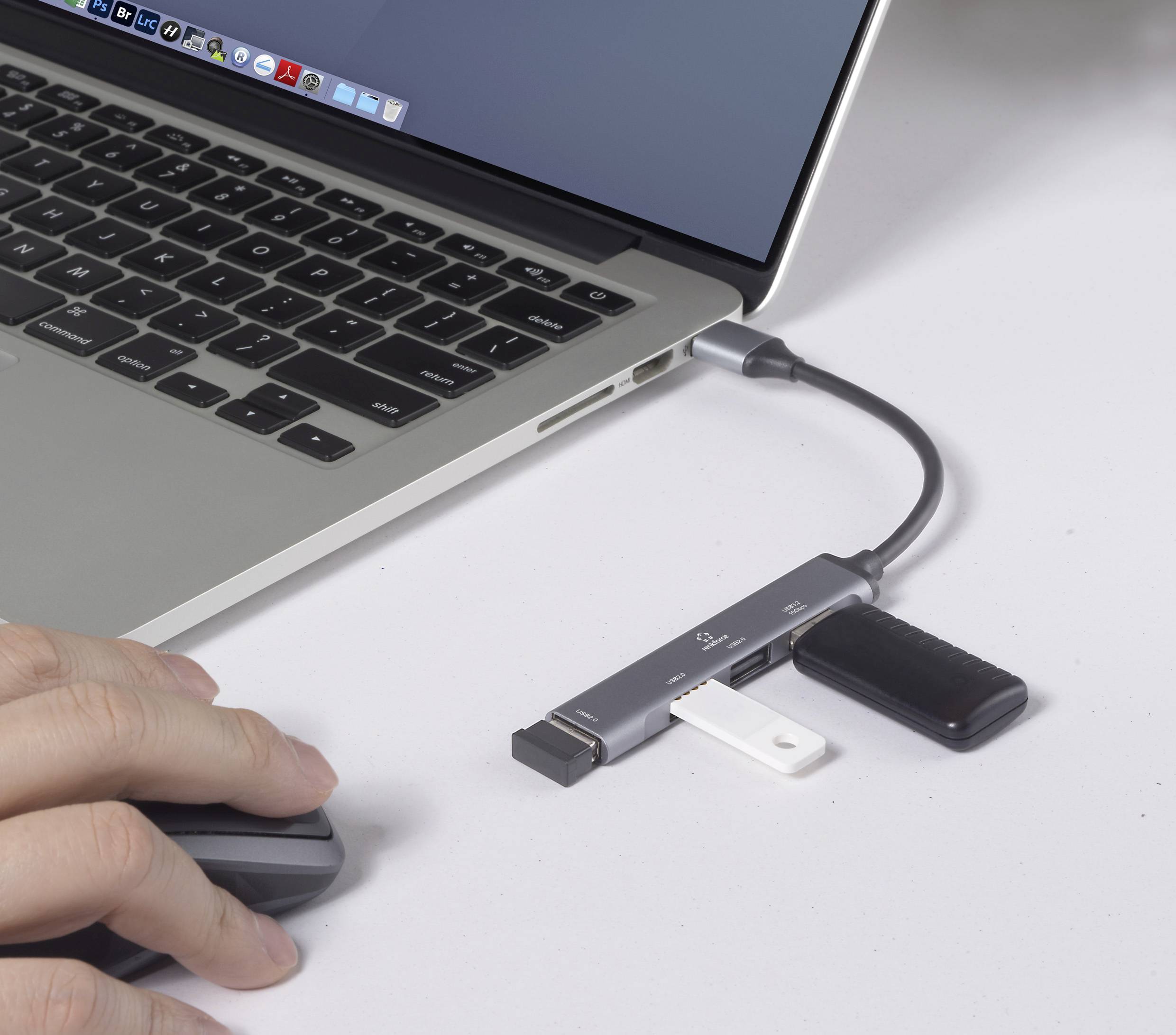 Ein Benutzer bedient einen Laptop mit mehreren über einen Hub verbundenen USB-Geräten, was eine Multitasking- oder Datenübertragungseinrichtung veranschaulicht.