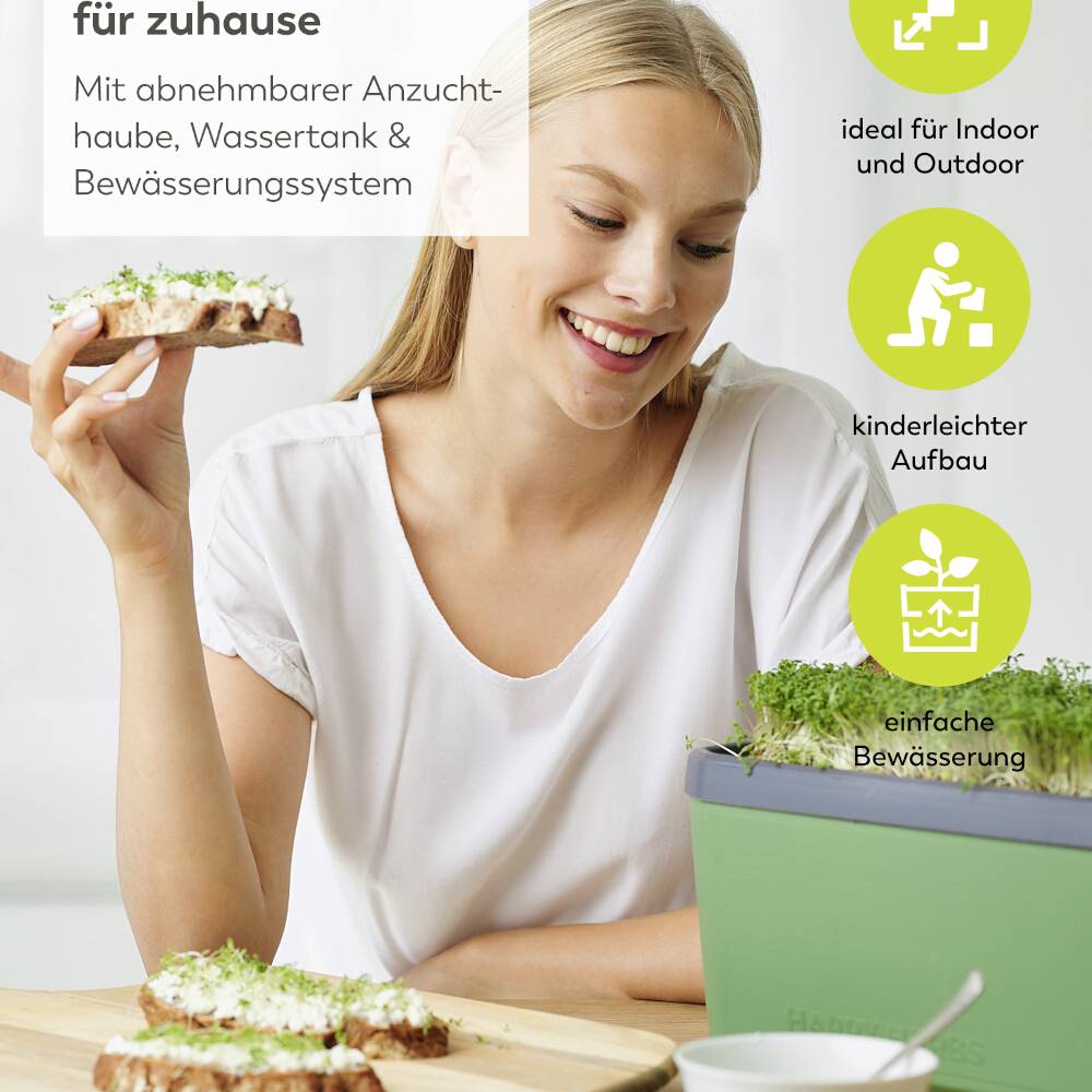 Ein lächelnder Mensch hält ein Brot mit Kräutern. Neben ihm eine Pflanze in einem Anzuchtbehälter. Text: 'ideal für Indoor und Outdoor', 'kinderleichter Aufbau', 'einfache Bewässerung'.