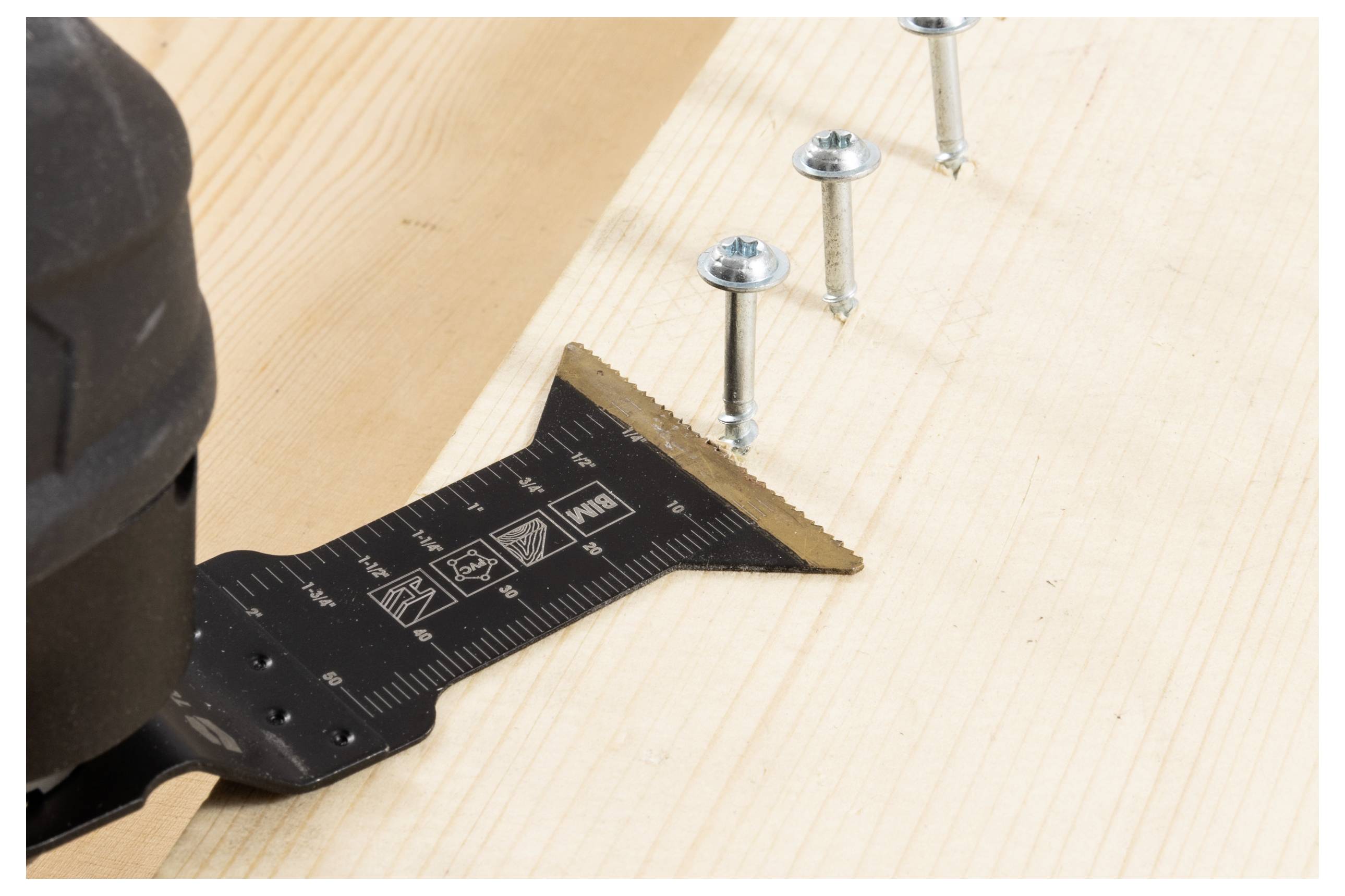 Ein Elektrowerkzeug wird an einem Winkelmesser auf einem Holzbrett ausgerichtet, während Schrauben teilweise eingedreht sind und auf eine laufende Bauarbeit oder Montage hindeuten.