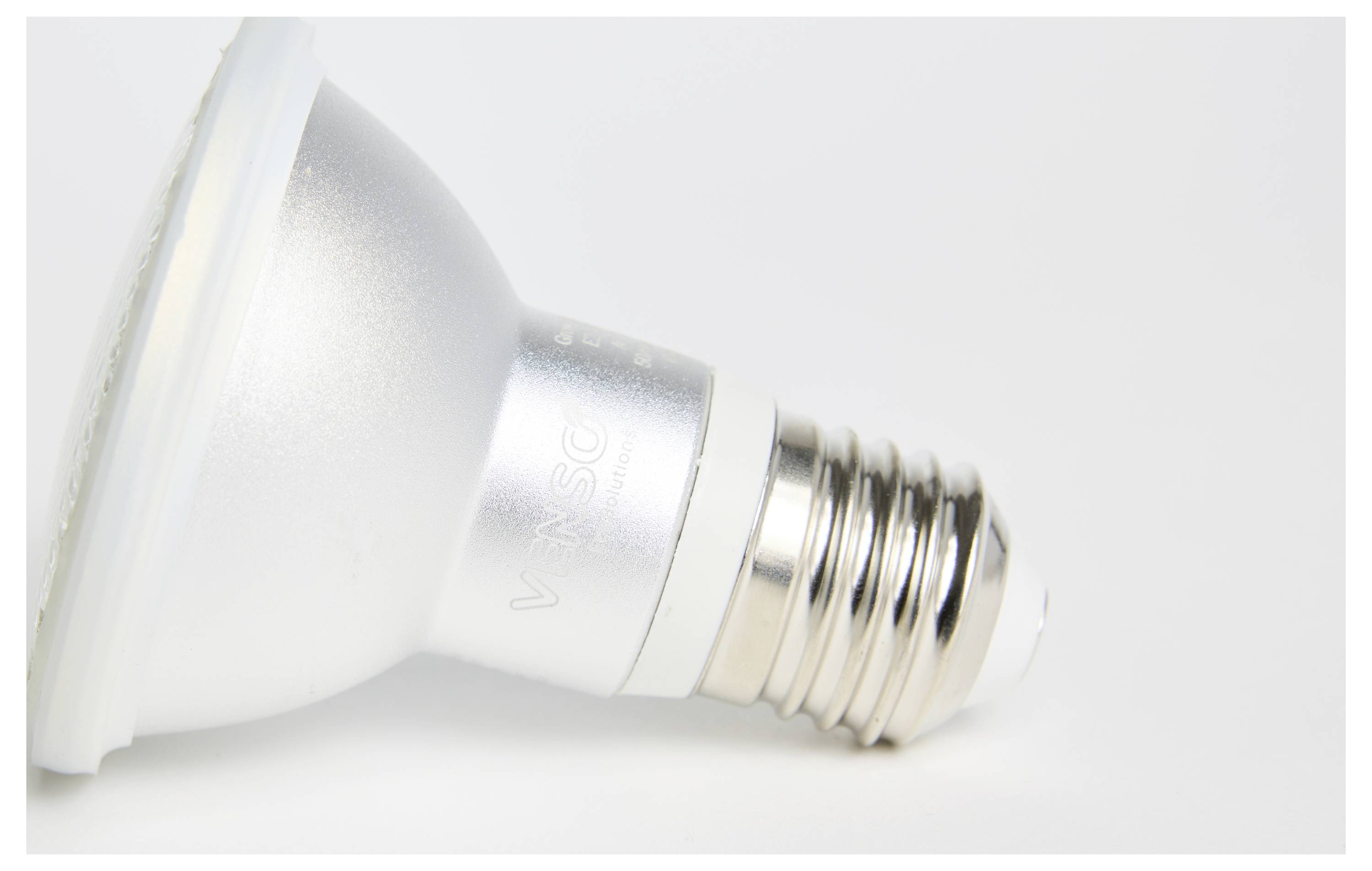 Eine LED-Glühbirne liegt seitlich auf einer weißen Oberfläche. Sie hat eine silberne Fassung und einen standardisierten Schraubsockel.