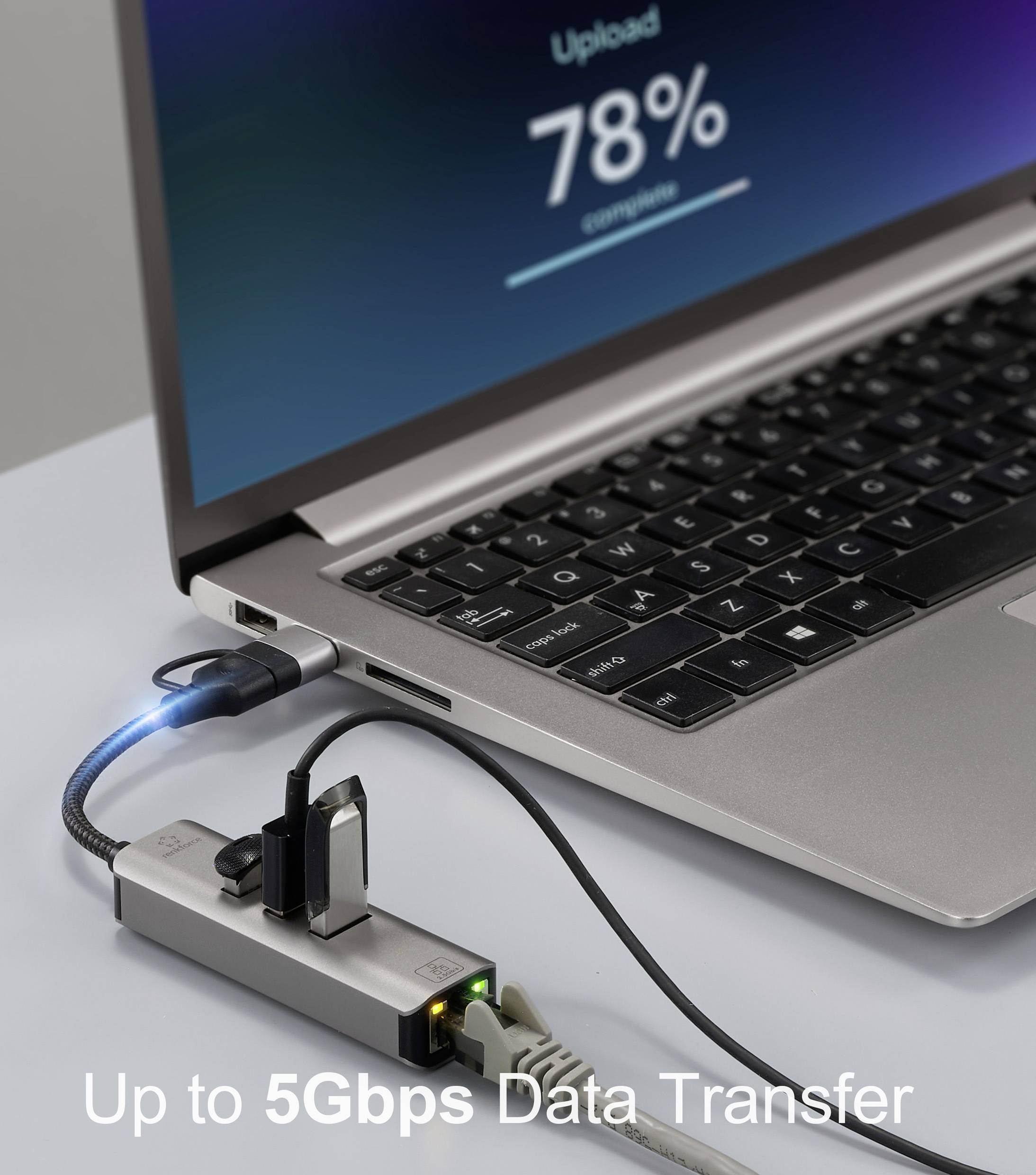 Ein Laptop, der an einen USB-Hub angeschlossen ist und 78% Uploadfortschritt auf dem Bildschirm zeigt. Text liest sich: 