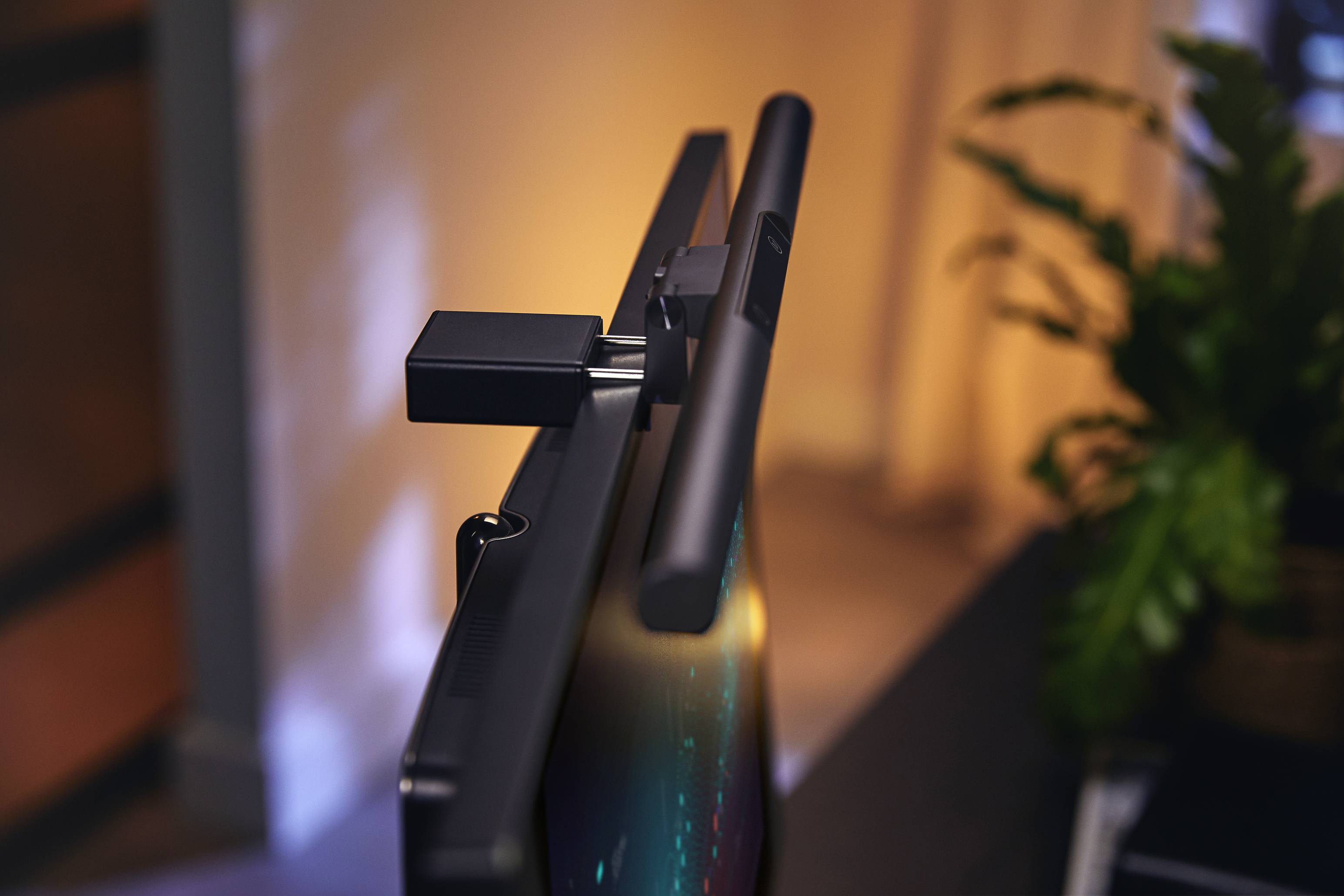 Eine Monitorleuchte ist auf einem Flachbildschirm montiert, mit unscharfer Pflanze im Hintergrund. Beleuchtet und modern.