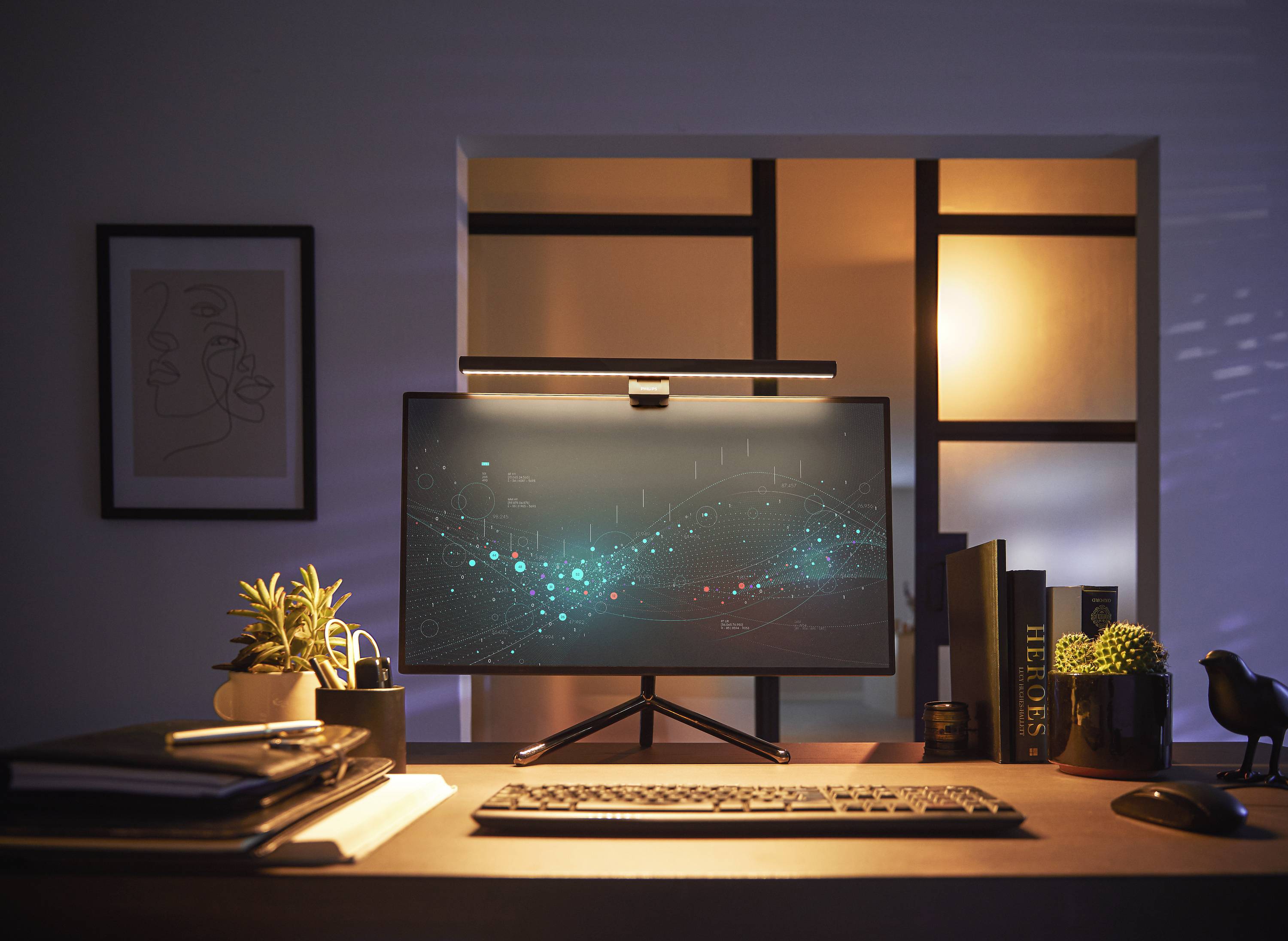 Ein Computerbildschirm auf einem Schreibtisch zeigt eine digitale Datenvisualisierung. Pflanzen und Bücher sind ebenfalls auf dem Tisch.