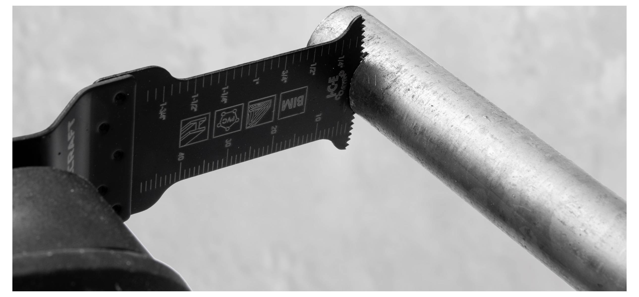 Eine Metallsäge mit Linealmarkierungen ist mit einem Metallrohr ausgerichtet und zeigt Messung oder Vorbereitungen zum Schneiden in einer Werkstattumgebung.