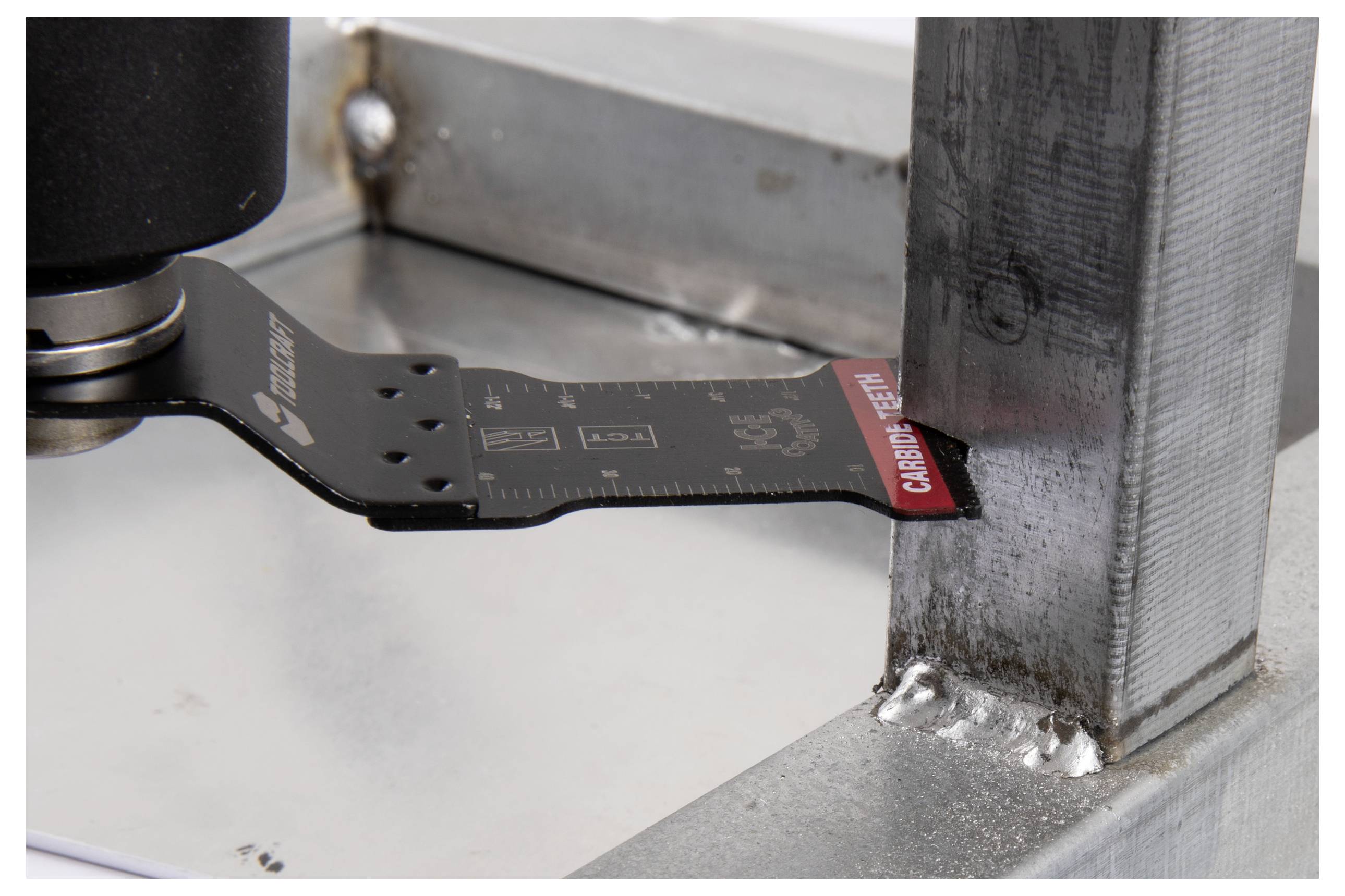 Ein schwarzes Messschieber-Werkzeug, das die Dicke von Metall misst, mit einer Nahaufnahme der Messskalierung in Millimetern vor einem Stahlträger.