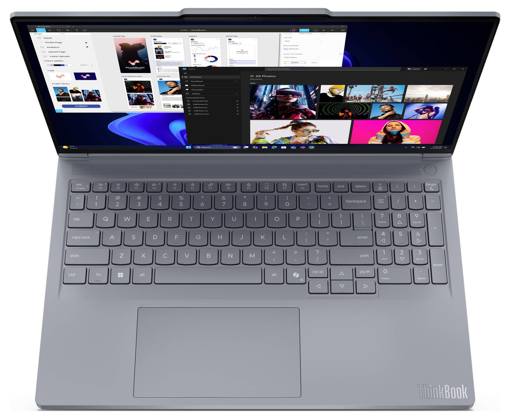 Ein schlanker grauer Laptop mit einem großen Bildschirm, auf dem mehrere geöffnete Anwendungen, einschließlich einer Fotogalerie, vor einem blauen Hintergrund zu sehen sind.