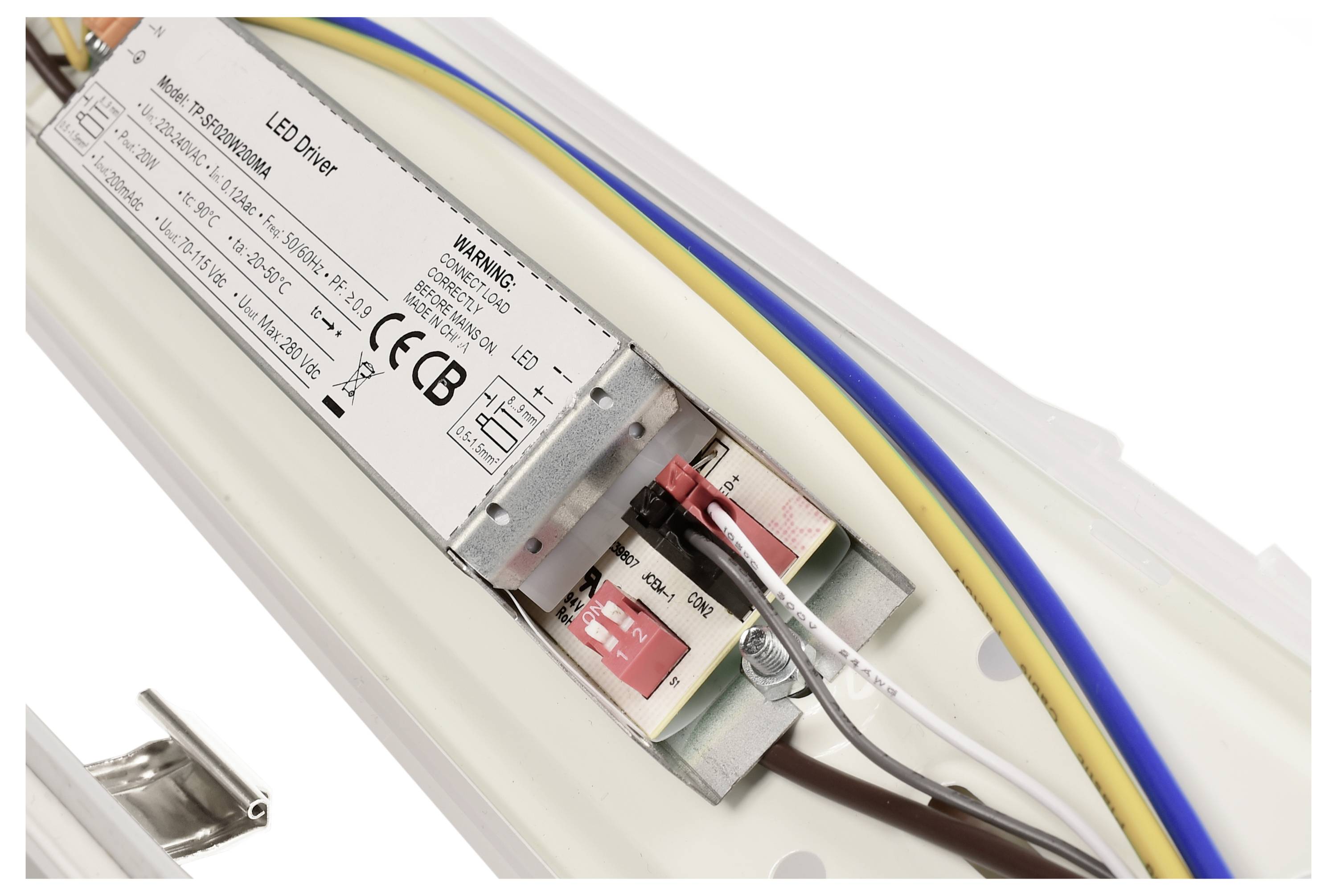 Ein LED-Treiber-Modul mit mehreren Kabeln ist auf einer weißen Kunststoffoberfläche montiert.