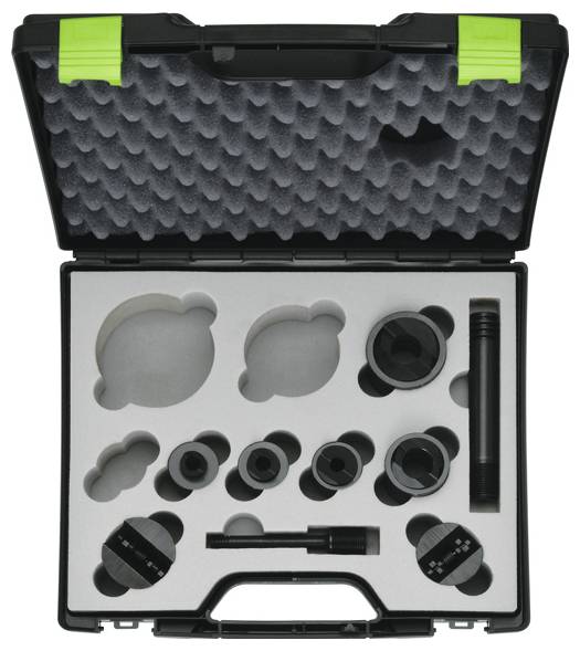 Ein schwarzer Koffer mit Schaumstoffeinsätzen enthält zwei große runde Werkzeuge, mehrere kleinere kreisförmige Komponenten und eine schlanke Stange, die zur Transportorganisation angeordnet sind.