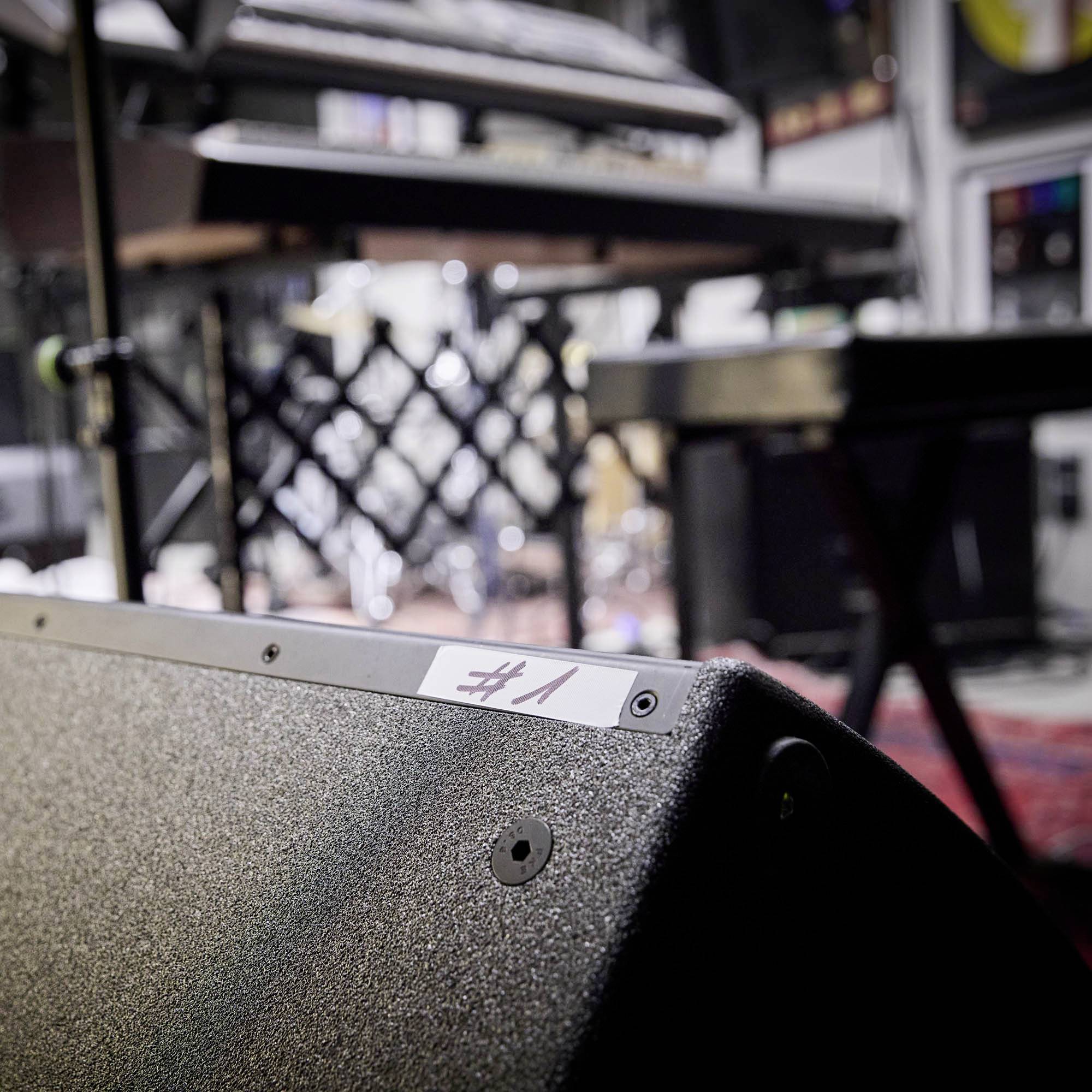 'Nr 1' auf einem Verstärker in einem Musikproberaum, unscharfes Hintergrundbild mit Instrumenten und Musikzubehör.
