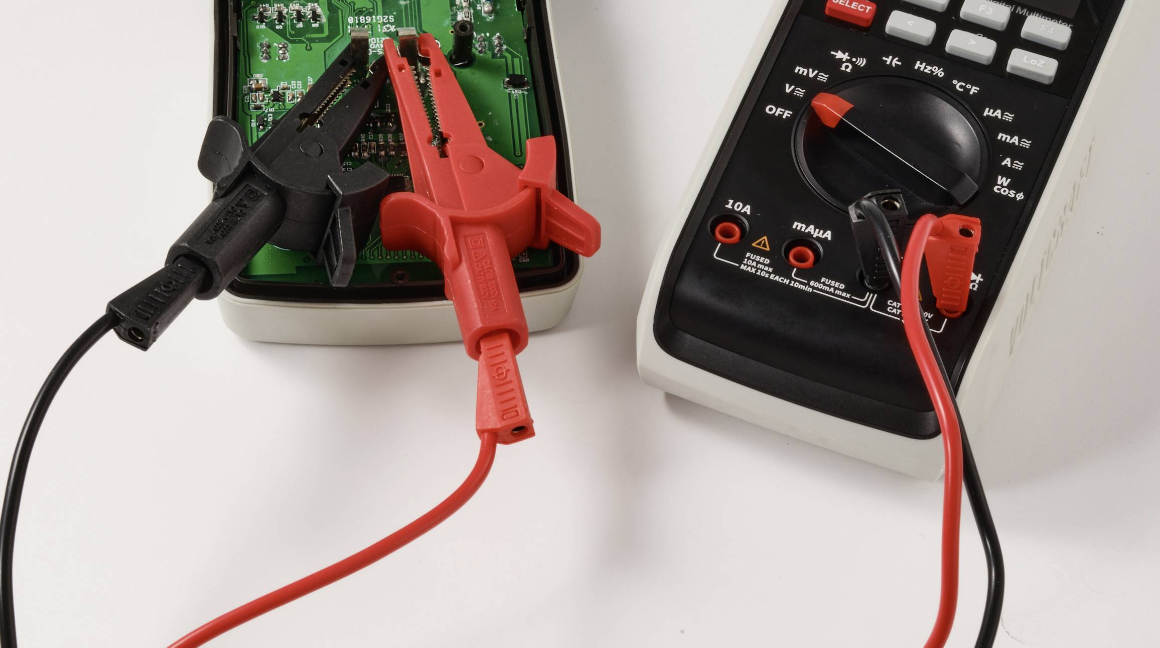 „Ein digitales Multimeter mit roten und schwarzen Messspitzen, die an eine Leiterplatte angeschlossen sind und auf eine laufende elektrische Messung hinweisen.