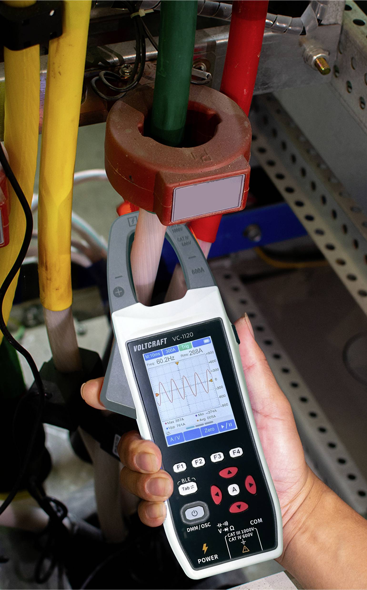 Ein Techniker misst den elektrischen Strom mit einem tragbaren Multimeter. Der Bildschirm zeigt ein Wellenmuster, und das Gerät ist mit Kabeln verbunden.