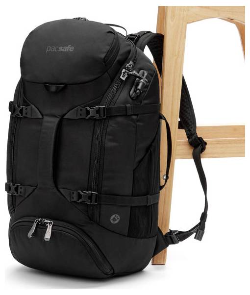 Ein schwarzer Rucksack mit mehreren Fächern ist an einem Holzstuhl befestigt. Der Rucksack hat Schnallen, Reißverschlüsse und verfügt über ein Sicherheitsschloss.