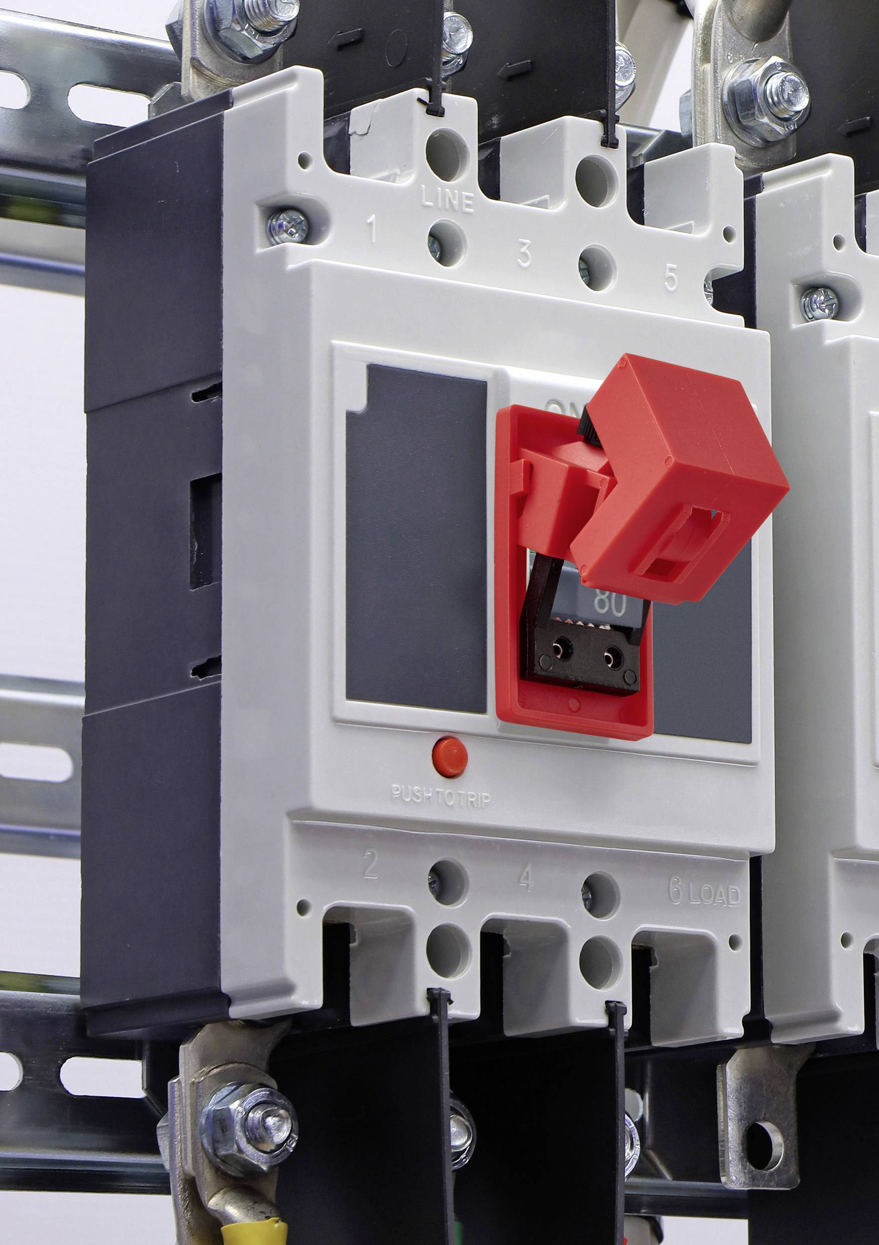 Nahaufnahme eines Leitungsschutzschalters mit einem roten Umschalter in einer Elektroverteilerdose, montiert auf einer Schiene.