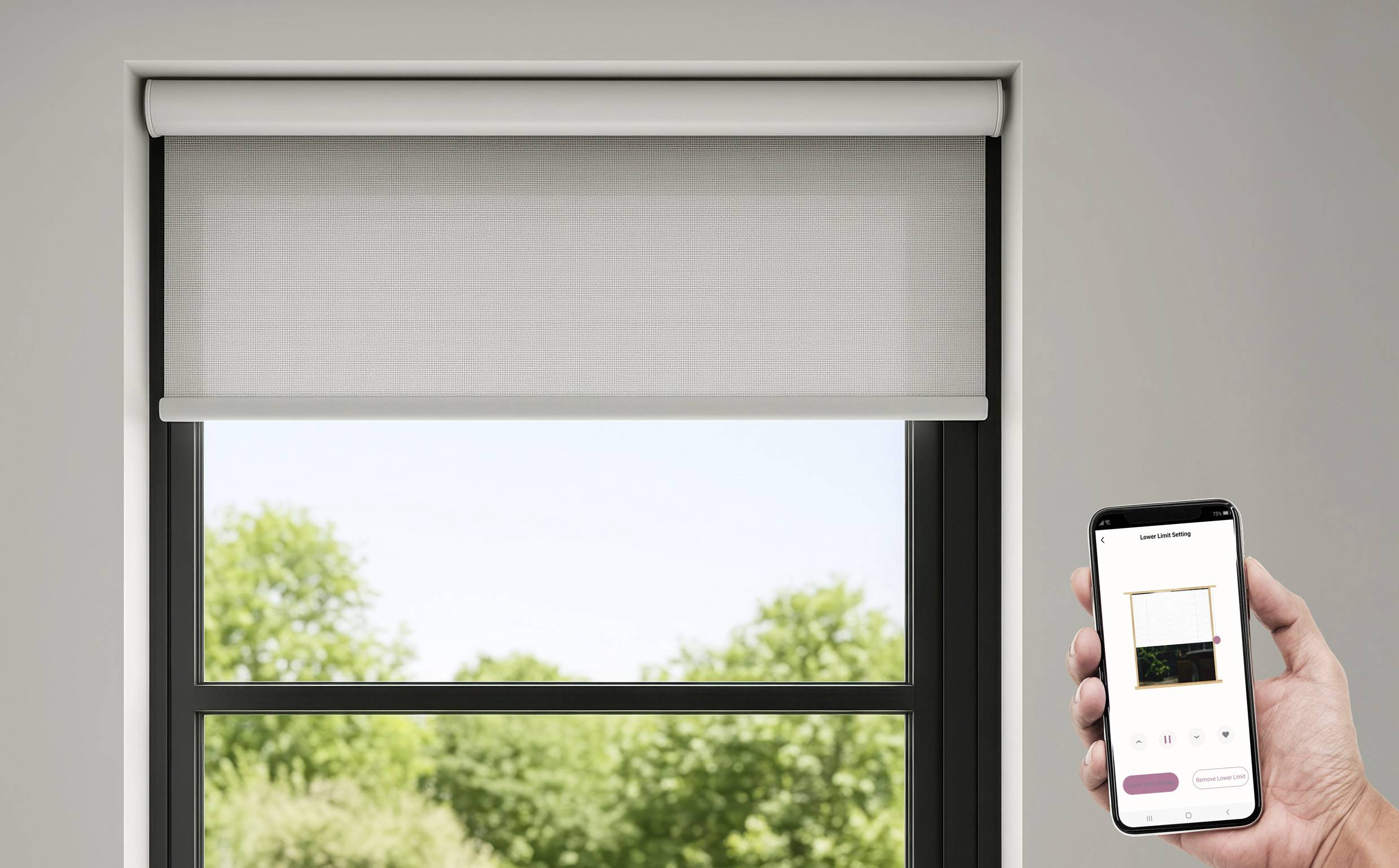 Eine Hand hält ein Smartphone, auf dem eine Fernbedienungs-App für eine Jalousie geöffnet ist. Die Jalousie ist teilweise hochgefahren und gibt den Blick auf Bäume draußen frei.