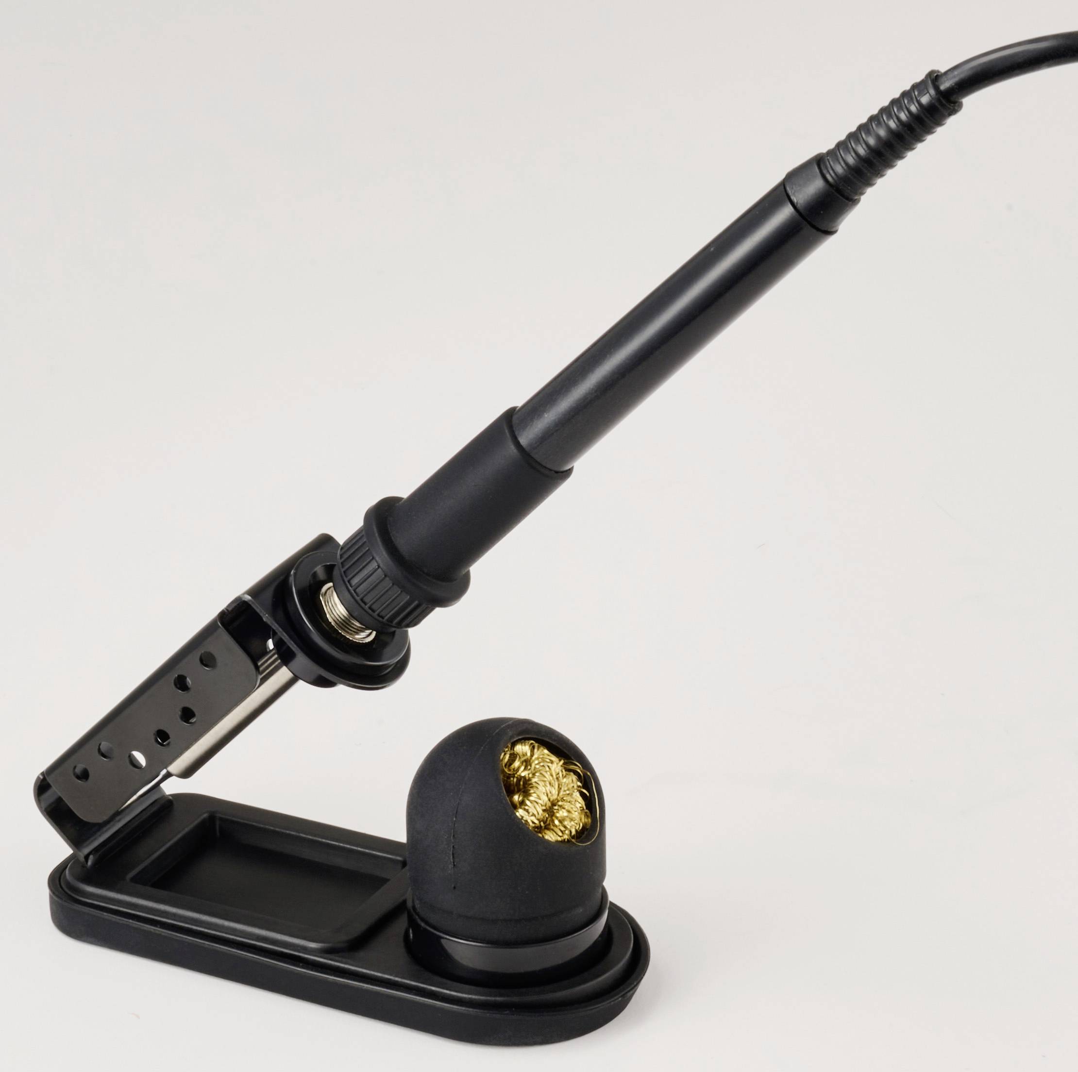 Ein schwarzer Lötkolben, der in einem Halter ruht, mit einer aufgewickelten Messingbürste zum Reinigen der Spitze, vor einem einfarbigen Hintergrund.