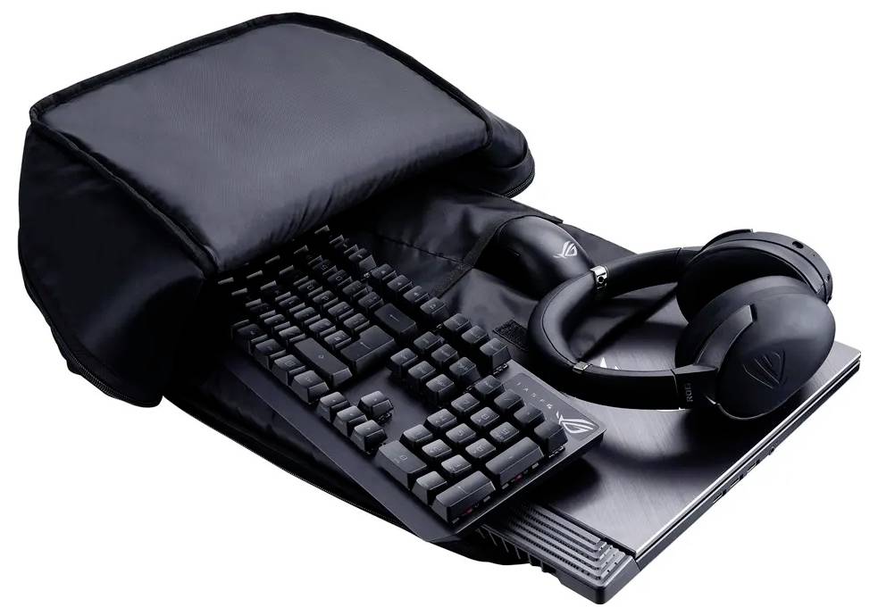 Ein Rucksack liegt offen und zeigt einen Laptop, eine Tastatur und Kopfhörer im Inneren, was eine kompakte Aufbewahrung von Computeraccessoires demonstriert.