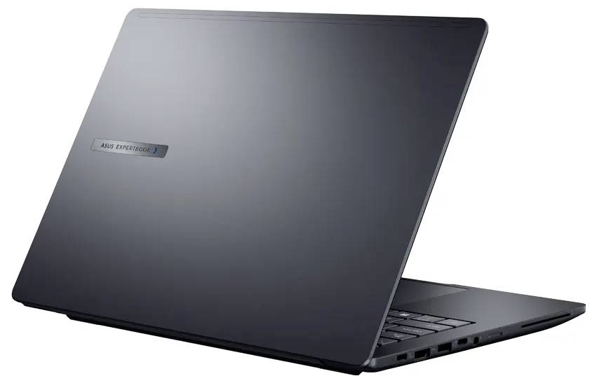 Geschlossener schwarzer Laptop aus einem Heckwinkel, mit Etikett und seitlichen Anschlüssen, vor einem einfarbigen Hintergrund.