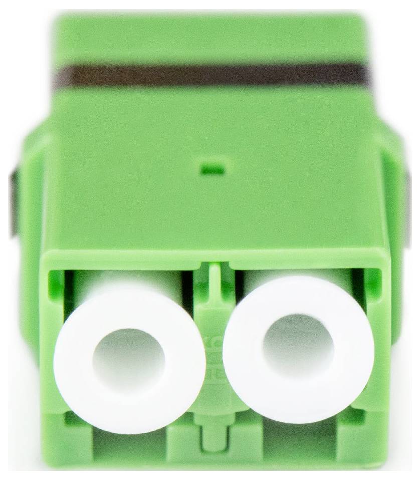 Ein Nahaufnahme eines grünen Glasfaseranschlusses mit zwei weißen Anschlüssen, verwendet zum Verbinden von optischen Fasern in Netzwerkausrüstung.