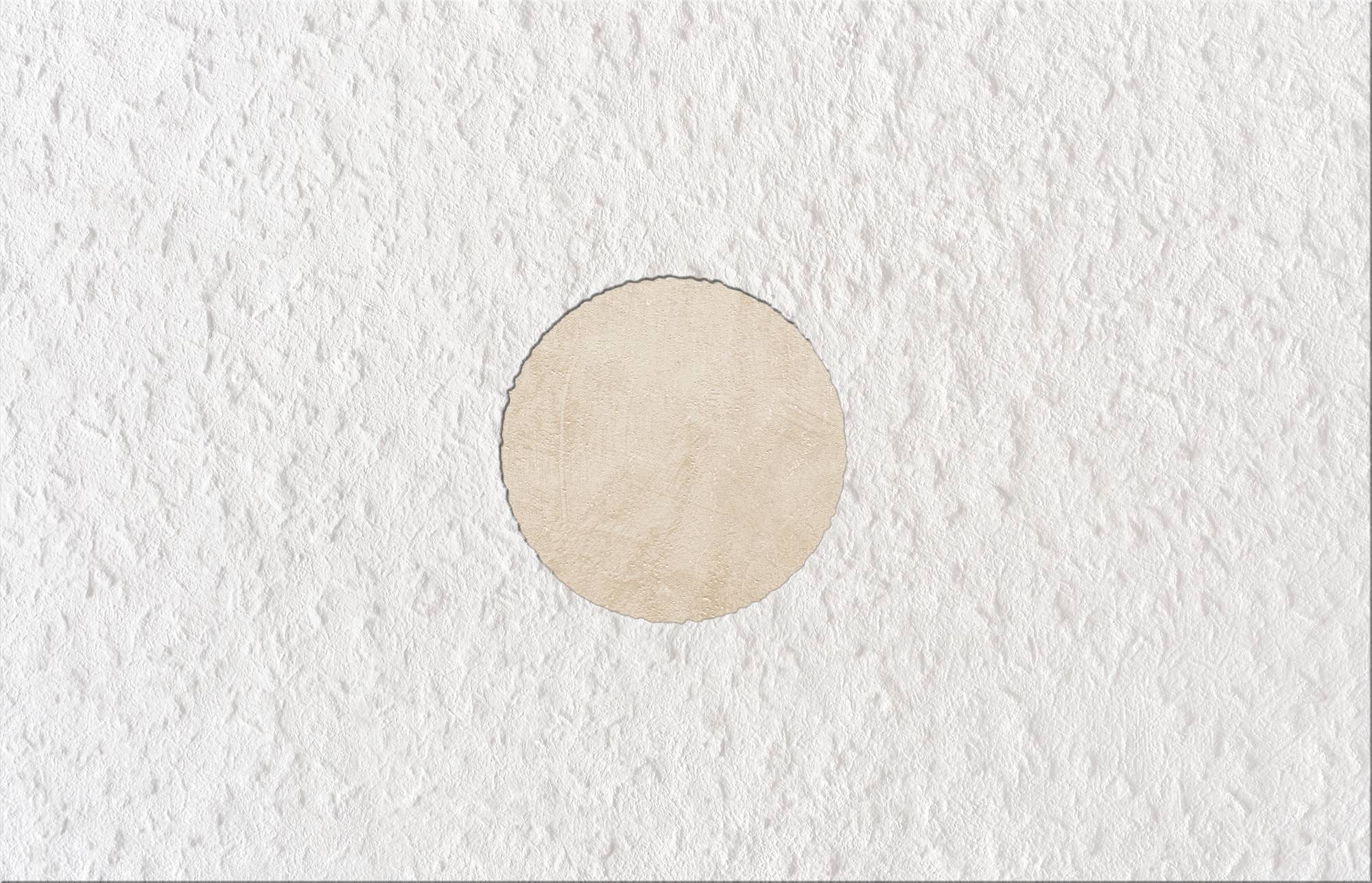 Ein kreisförmiges Objekt, das wie ein Ausschnitt auf einer strukturierten weißen Oberfläche aussieht.