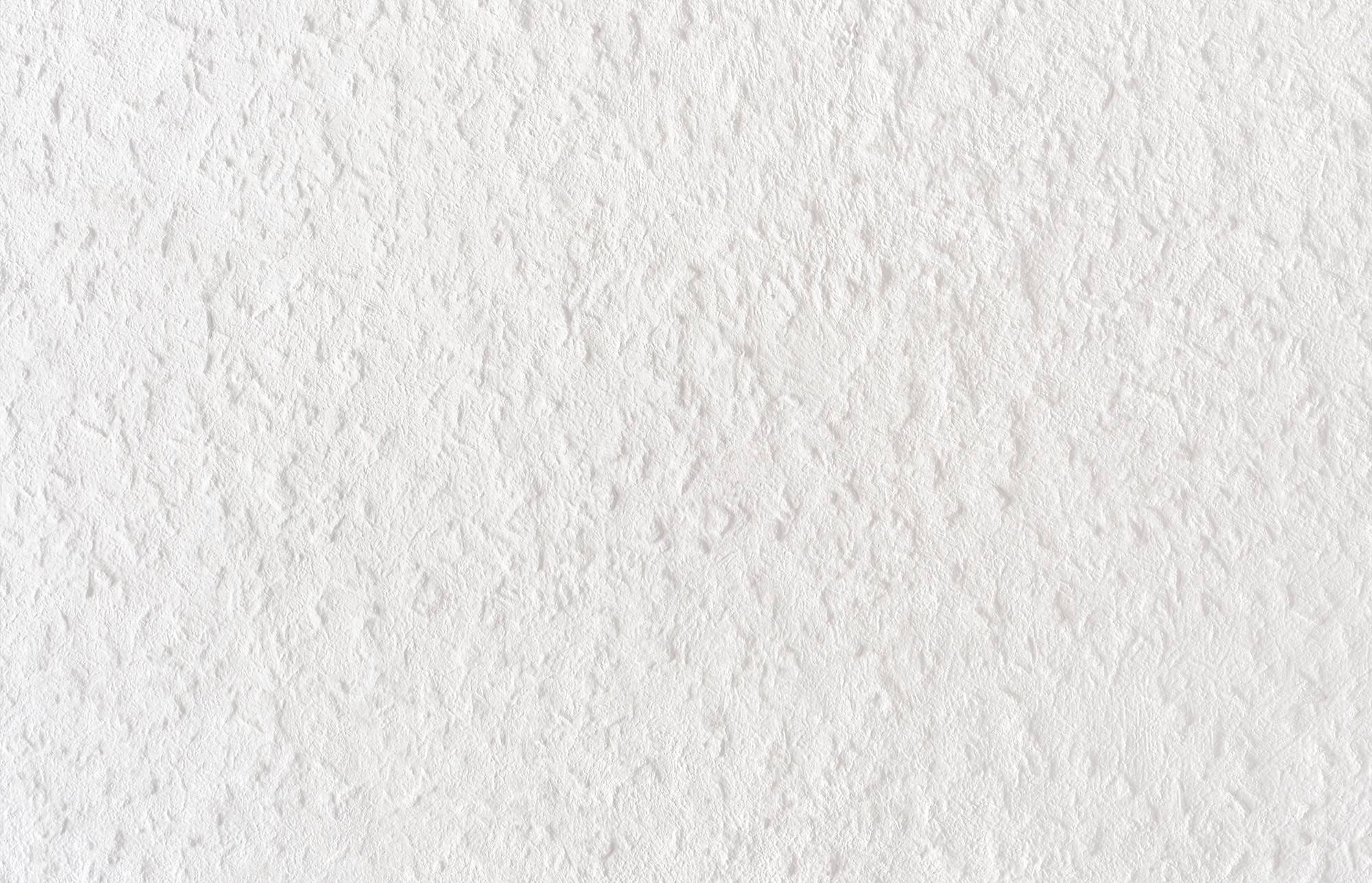 Nahaufnahme einer weißen Wand mit einer subtilen, rauen Oberflächenstruktur.