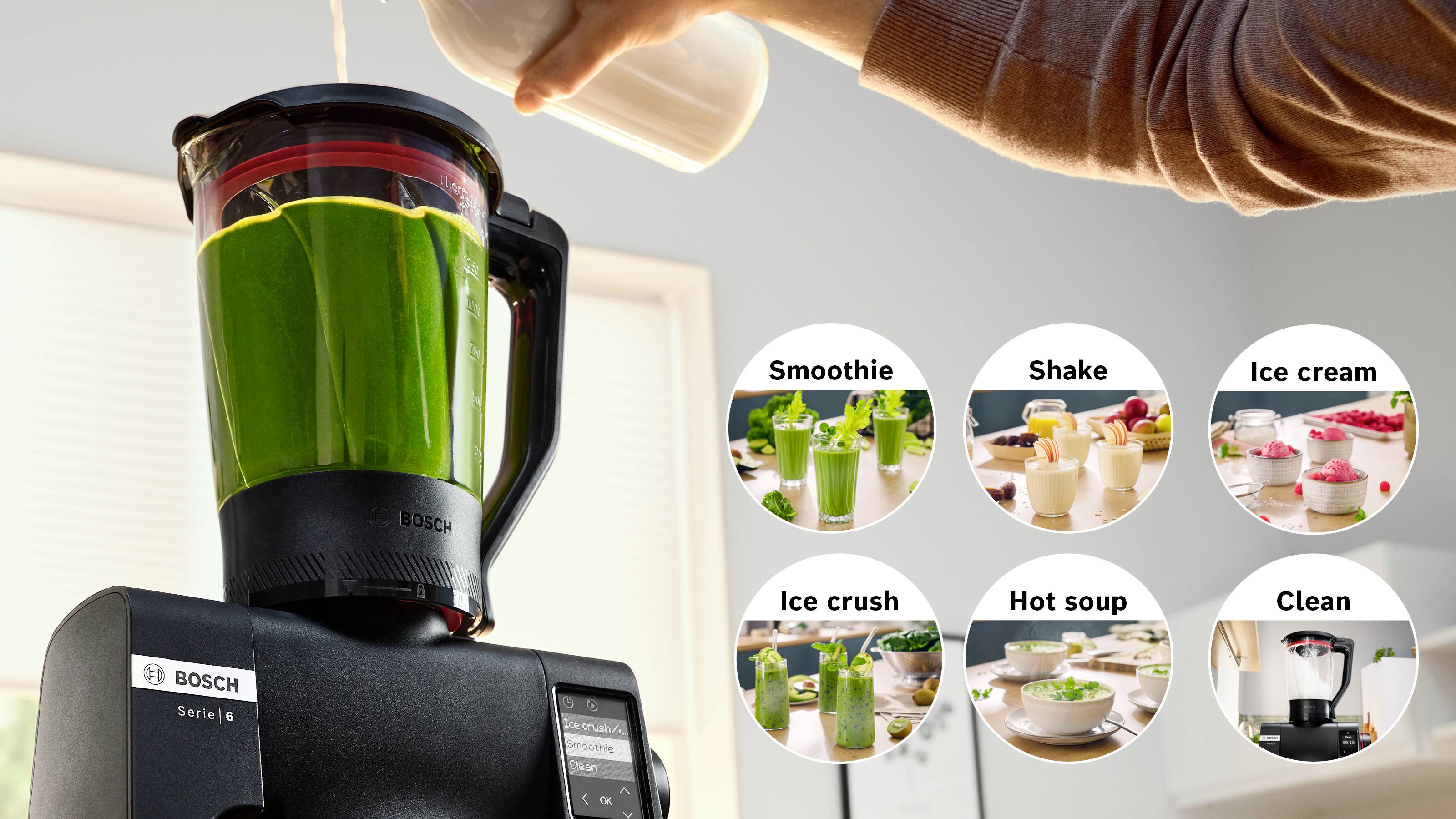 Ein Bosch-Mixer bereitet einen grünen Smoothie zu. Kreisförmige Einblendungen zeigen verschiedene Funktionen: Smoothie, Shake, Eiscreme, Eiscrushen, Heißer Suppe, Reinigen.