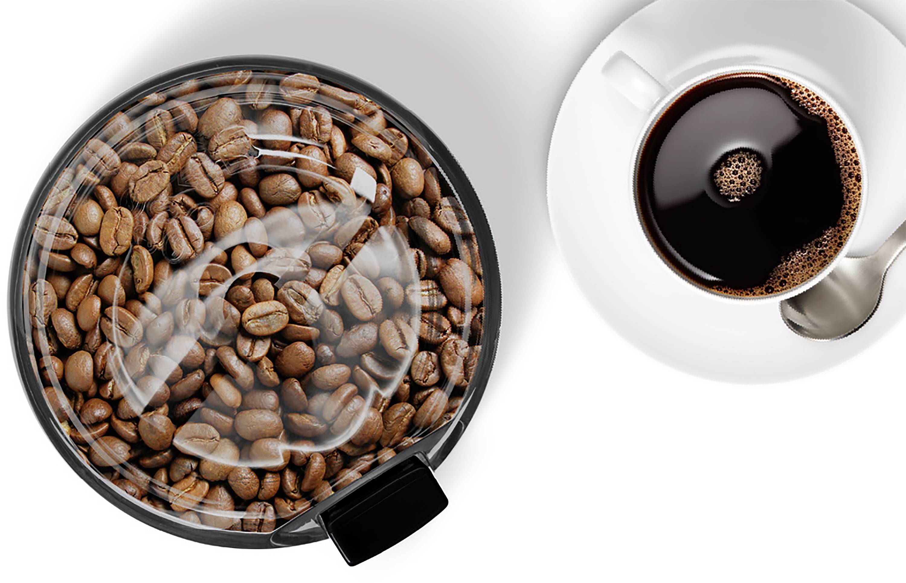 Draufsicht eines Glasgefäßes gefüllt mit Kaffeebohnen neben einer Tasse schwarzem Kaffee mit einem Löffel auf einem weißen Unterteller.