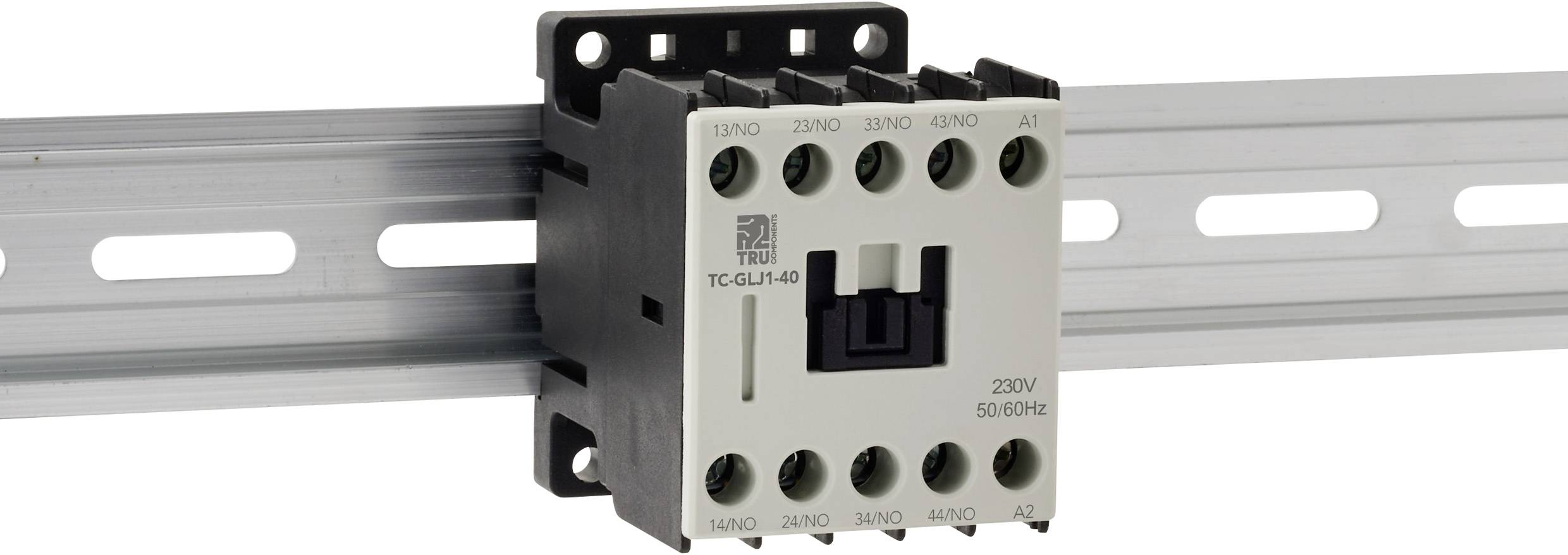 Ein elektrischer Schütz, montiert auf einer Hutschiene, mit beschrifteten Anschlusspunkten für Verdrahtung, in einem grauen Gehäuse mit schwarzem Schalter.
