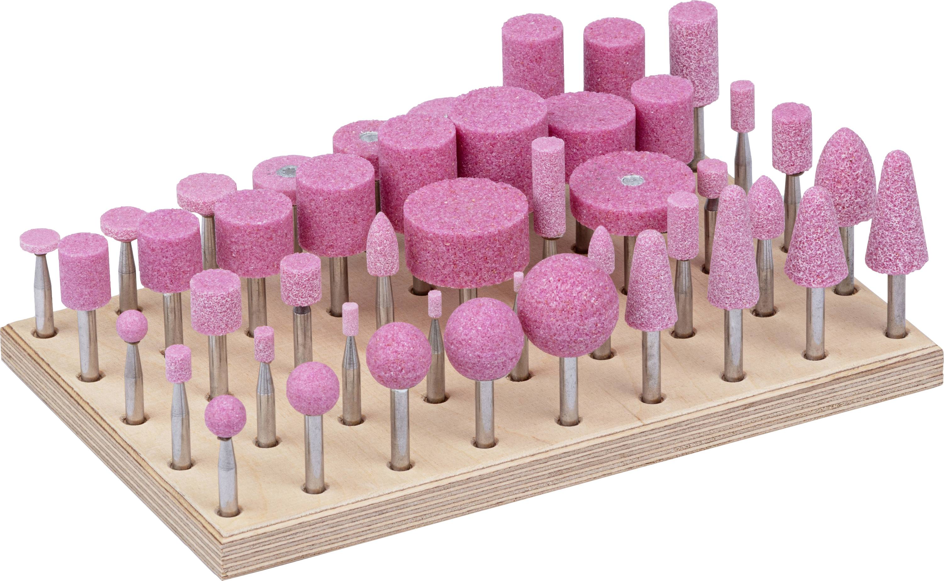 Verschiedene rosa Schleifköpfe in unterschiedlichen Formen und Größen, die auf einer Holzunterlage angeordnet sind.