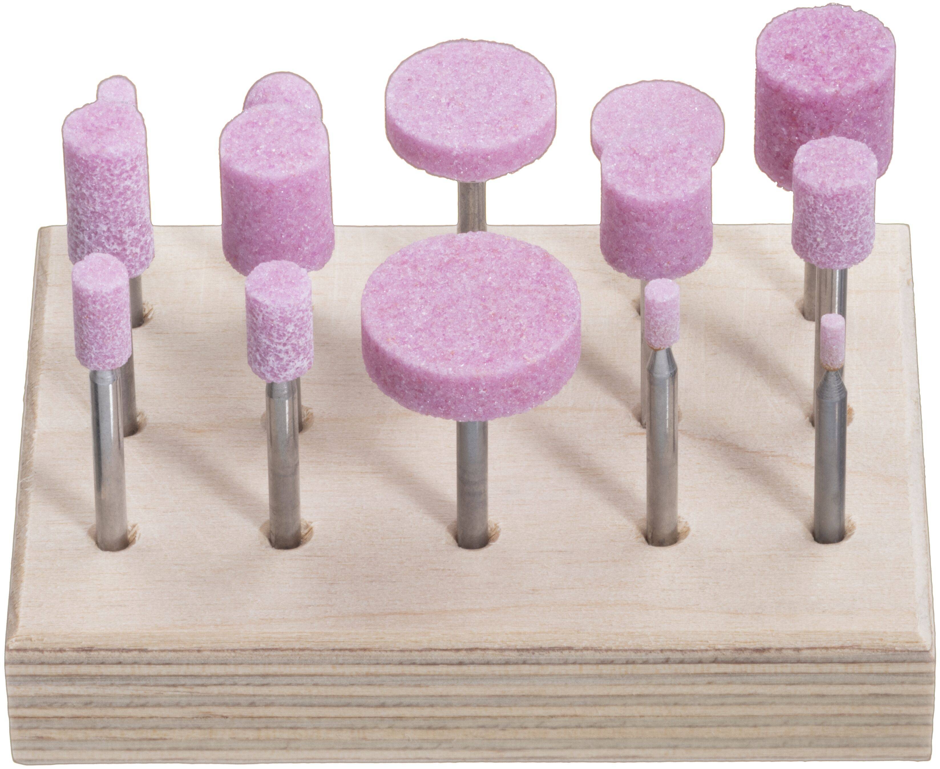 Ein Holzhalter, der zehn rosa Schleif- und Polieraufsätze in verschiedenen Formen und Größen auf Metallschäften zur Bearbeitung und Glättung zeigt.