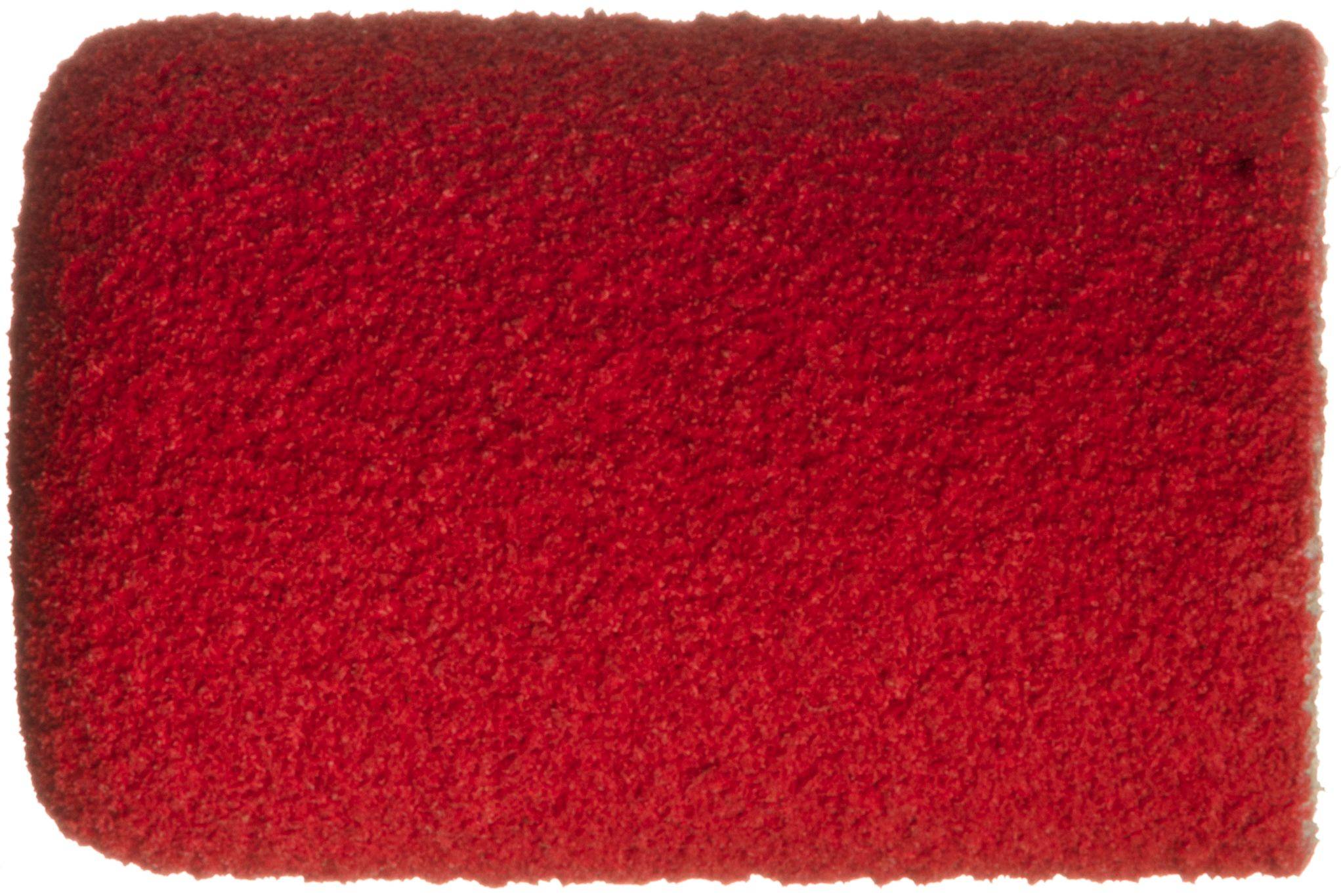 Ein aufgerollter roter Teppich mit strukturierter Oberfläche, der häufig bei besonderen Veranstaltungen oder Zeremonien verwendet wird.