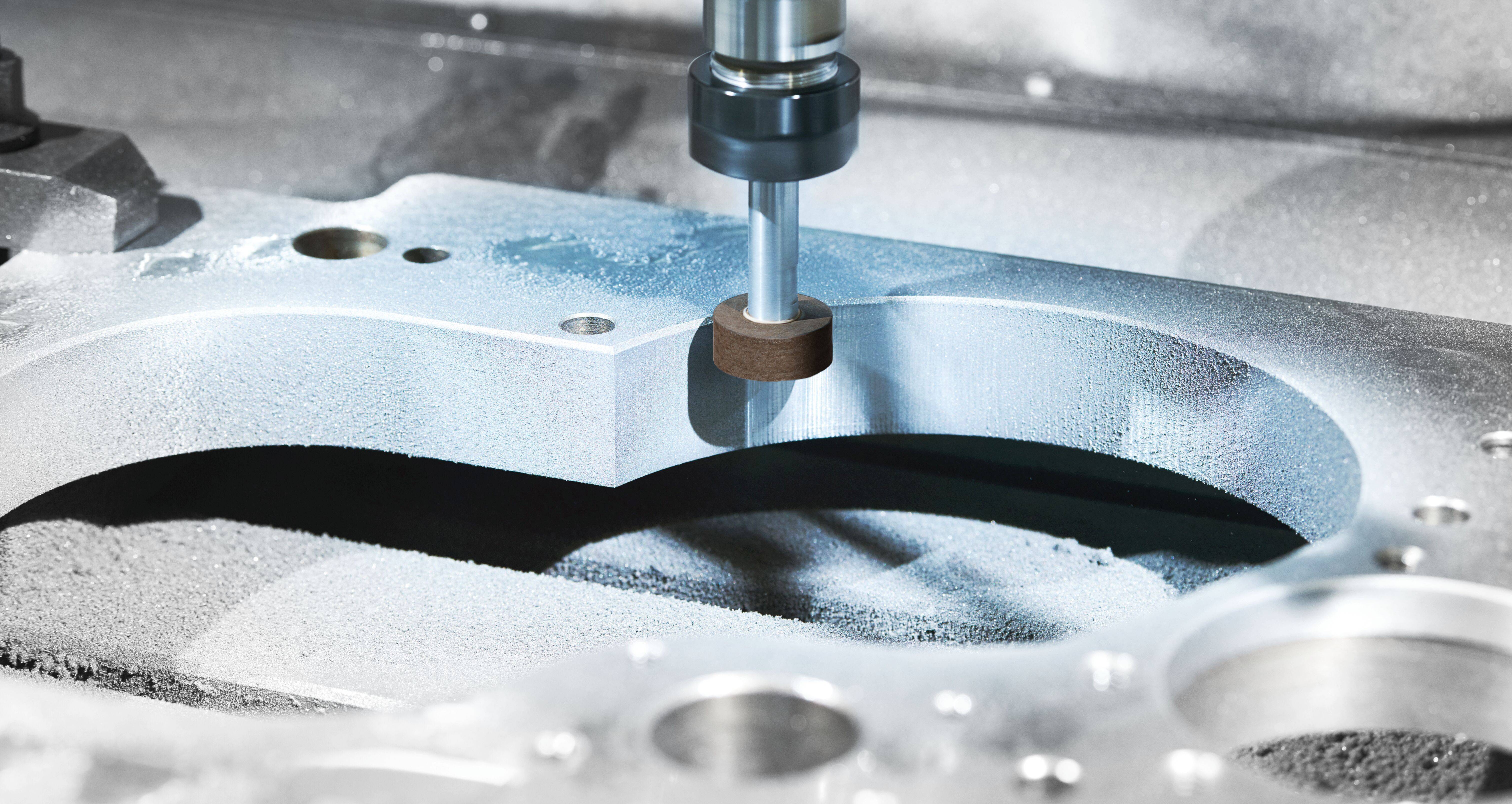 Eine CNC-Maschine verwendet ein rotierendes Werkzeug, um eine Metallkomponente zu schneiden und zu formen und demonstriert dabei Präzisionstechnik in einer Werkstattumgebung.