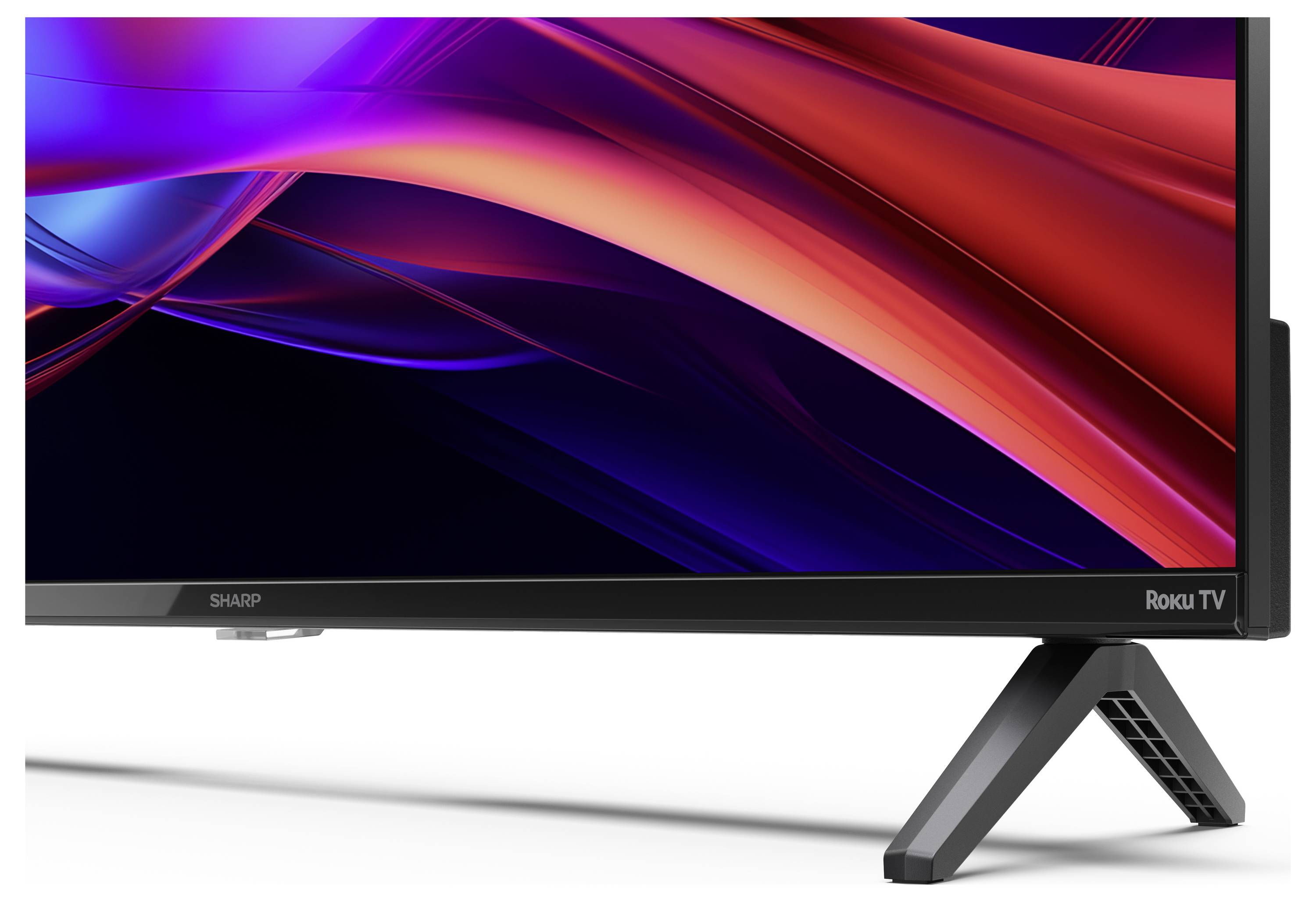 Eine Nahaufnahme eines Roku-Fernsehers, die die scharfen Kanten und die lebendigen Rot- und Violetttöne auf dem Bildschirm betont, wobei ein Teil des Ständers sichtbar ist.