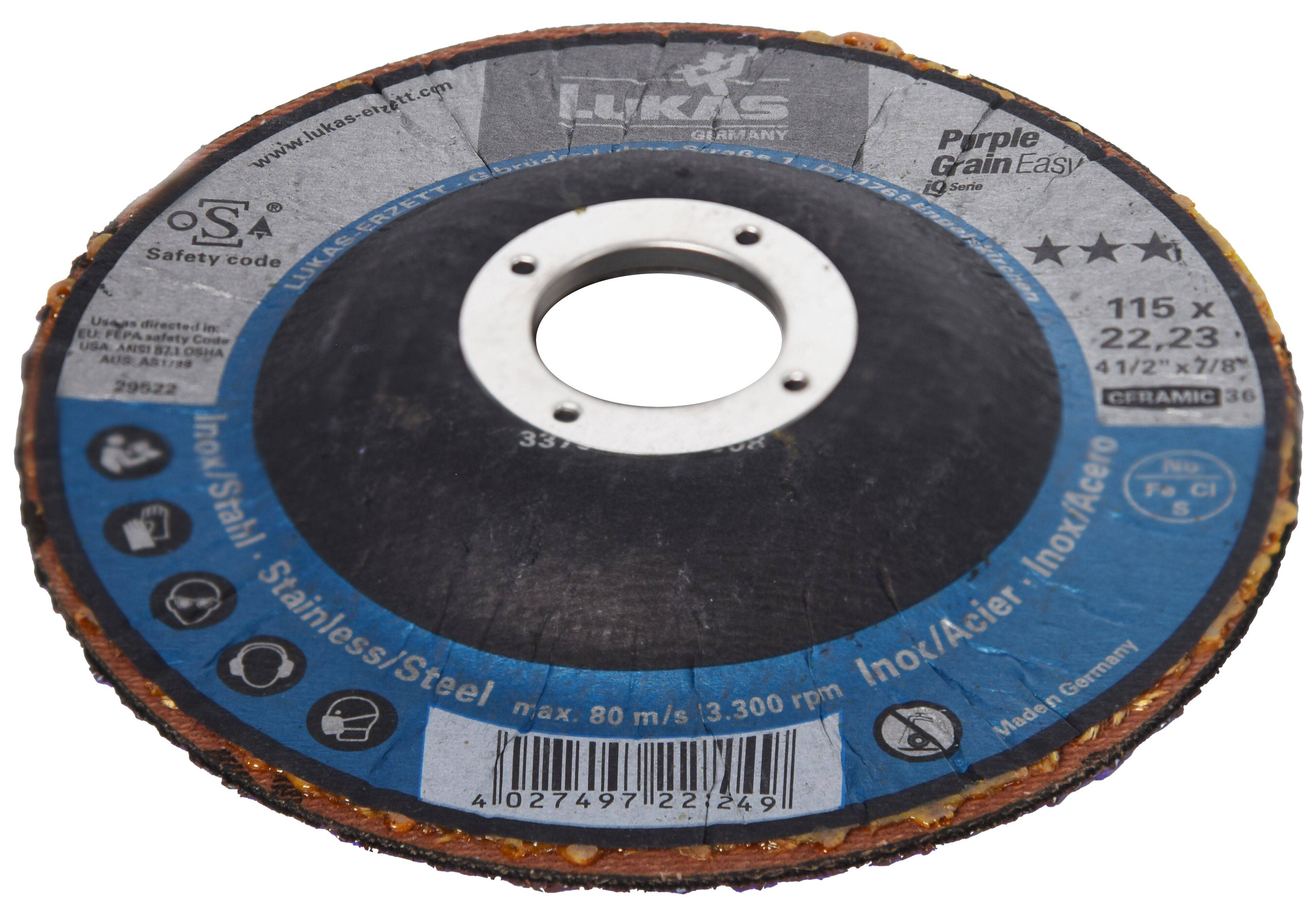 Eine Kreisschleifscheibe mit einem zentralen Loch, gekennzeichnet für den Einsatz an Edelstahl. Die Scheibe ist mit verschiedenen Sicherheits- und Verwendungsmarkierungen versehen.