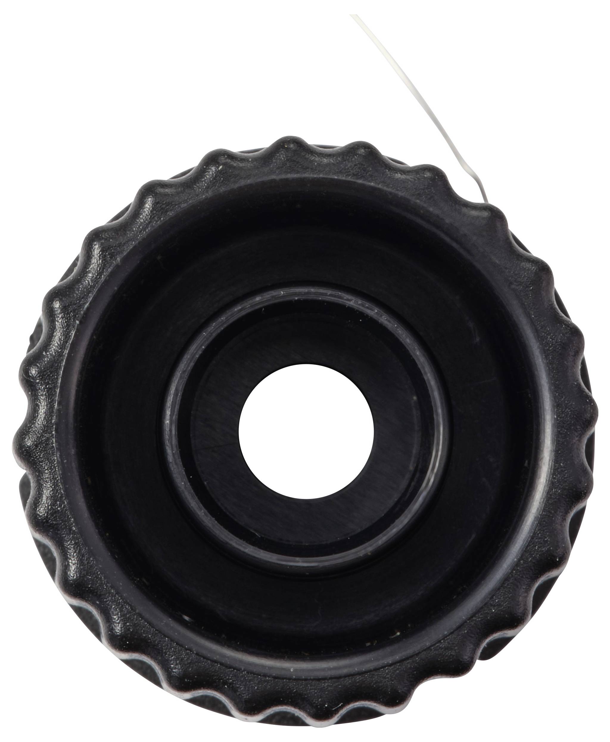 Ein schwarzes zahnradförmiges Objekt mit einem zentralen Loch, von oben betrachtet, mit gerilltem Rand und einem dünnen Draht, der von der oberen rechten Seite herausragt.